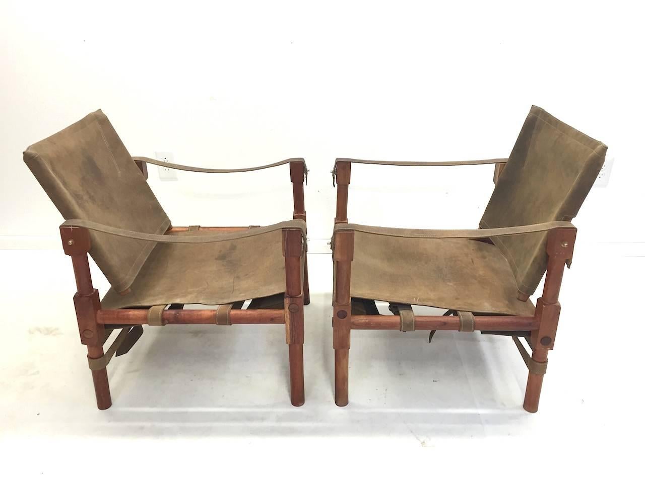 Pair of vintage safari lounge chairs. Very nicely constructed with fine brass hardware. Seats and backs have a patina from age.
