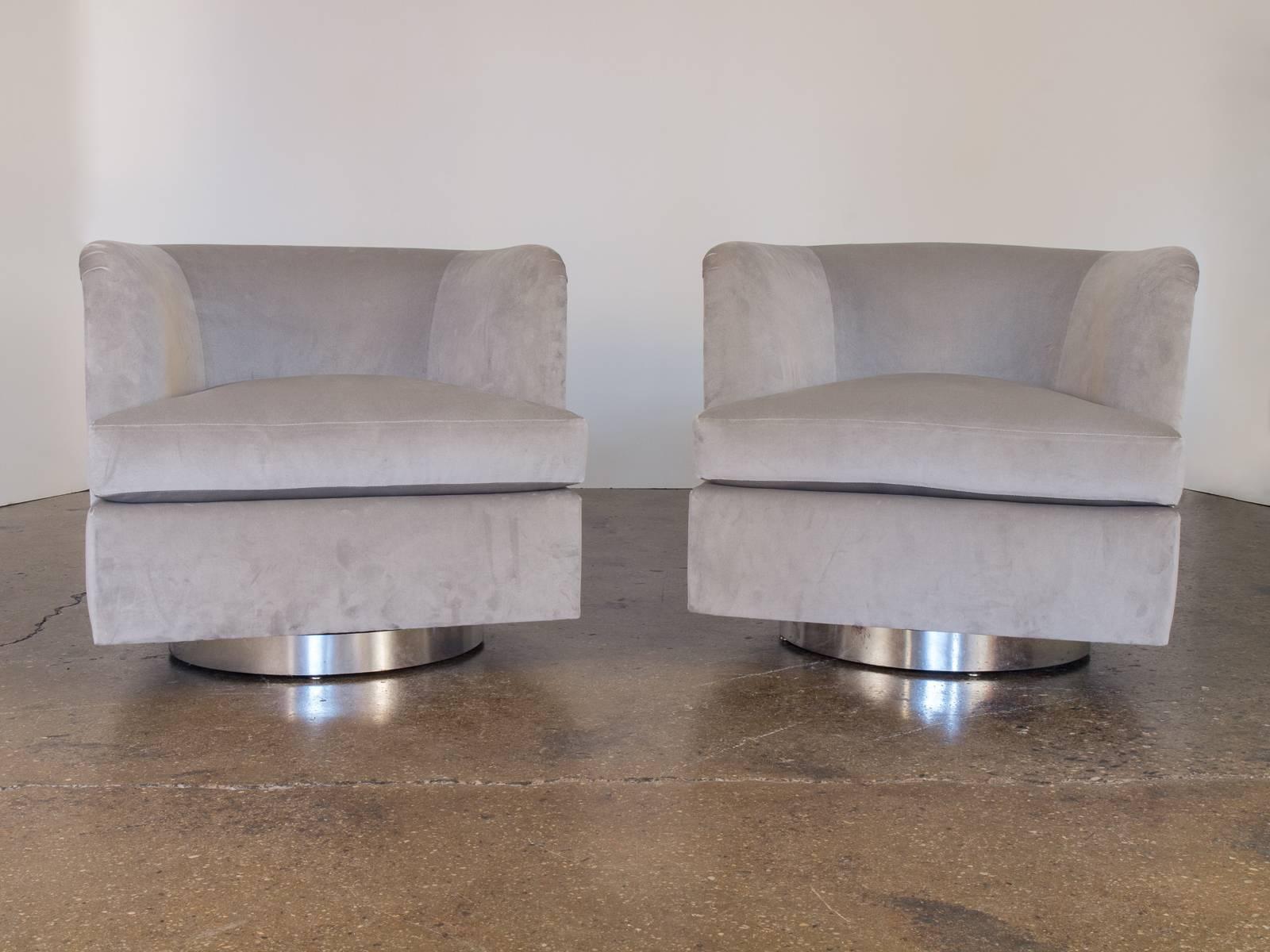 Pair of sleek 1960s swivel lounge chairs by Milo Baughman for Thayer Coggin. These chairs have a tilt feature that makes them supremely comfortable. Brushed metal banding. Newly recovered in luxurious romo velvet in a silvery gray.

Measures: