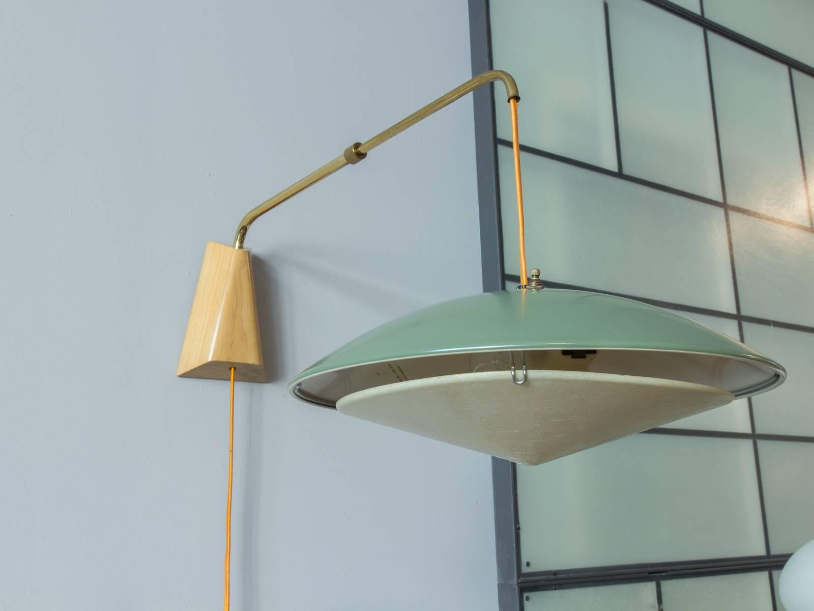 A vintage design by Gerald Thurston for Lightolier. These clever lights use a weighted pulley to adjust the height of the lamp, which can also telescope in and out from the wall and tilt from side to side. The inner shade is fiberglass, which gives