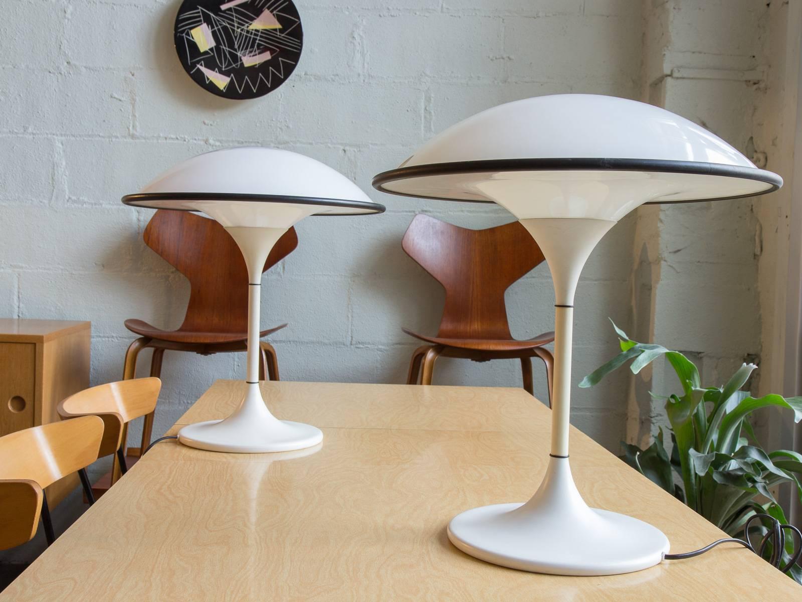 So mod! A pair of white UFO-shaped table lamps by Fog & Mørup, circa 1960. These groovy lamps have been rewired for US outlets. They cast a soft light due to the shades that wrap all around the fixtures. In very good condition with a couple of minor