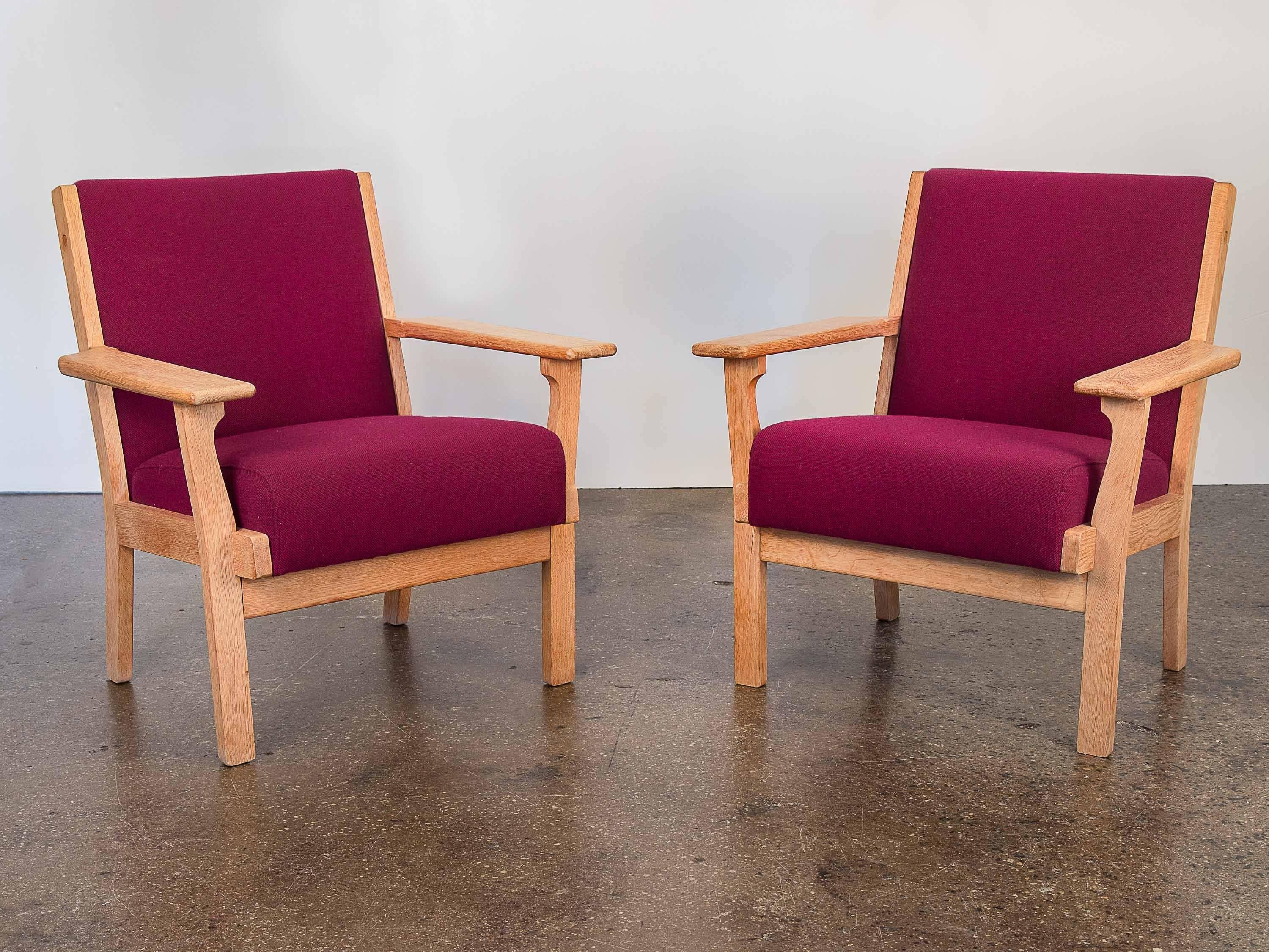 Pair of handsome Hans Wegner Oxblood armchairs for GETAMA. Newly upholstered in an oxblood Maharam Hallingdal fabric, these sturdy oak armchairs are ergonomic as they are cozy and comfortable. Sold as a pair.