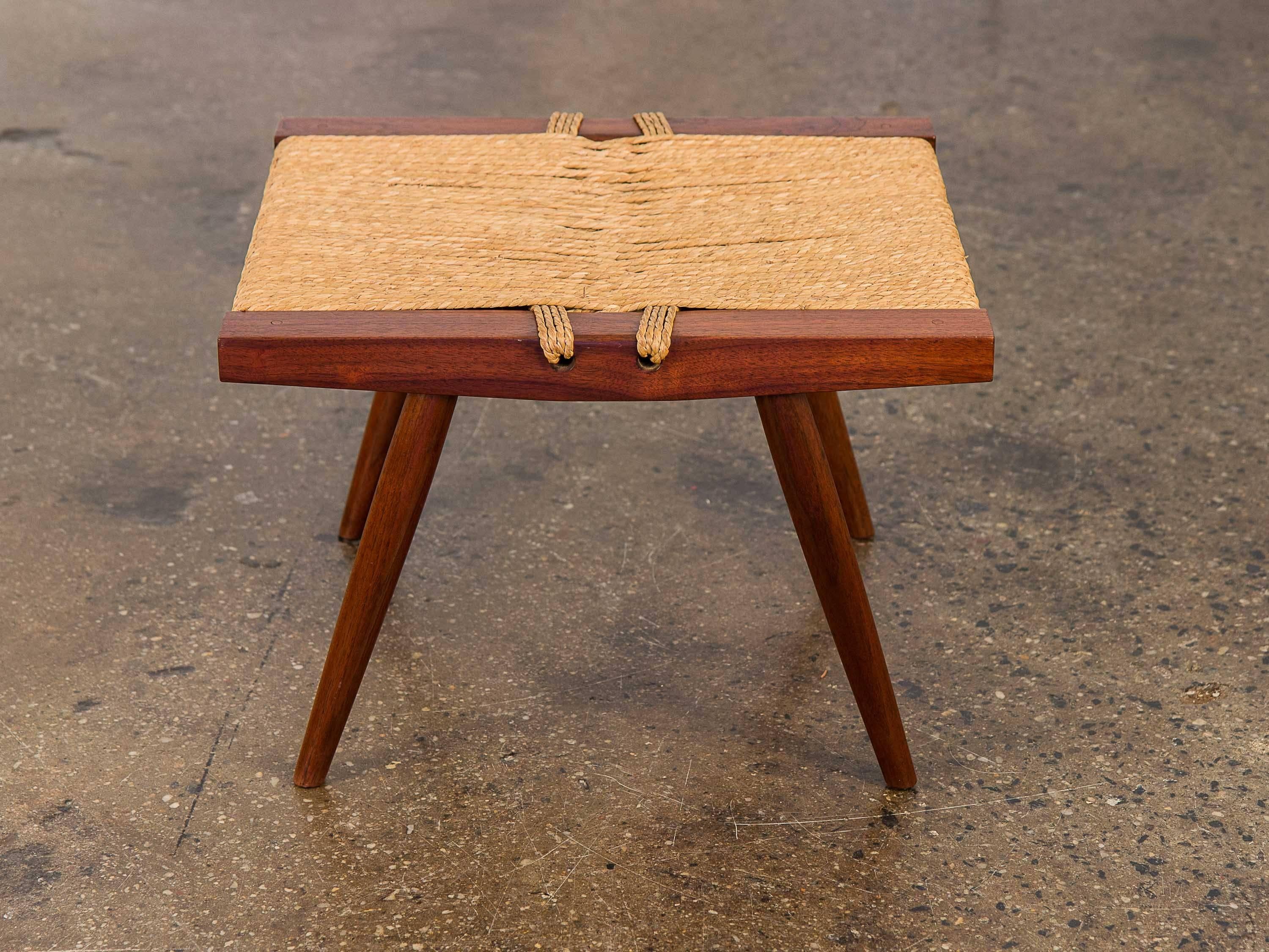 George Nakashima walnut stool with woven grass seat. Japanese knot technique used for the original sea-grass woven seat as well as the beautiful, rich walnut wood frame has seen little sign of wear and is in superb condition. Acquired from the