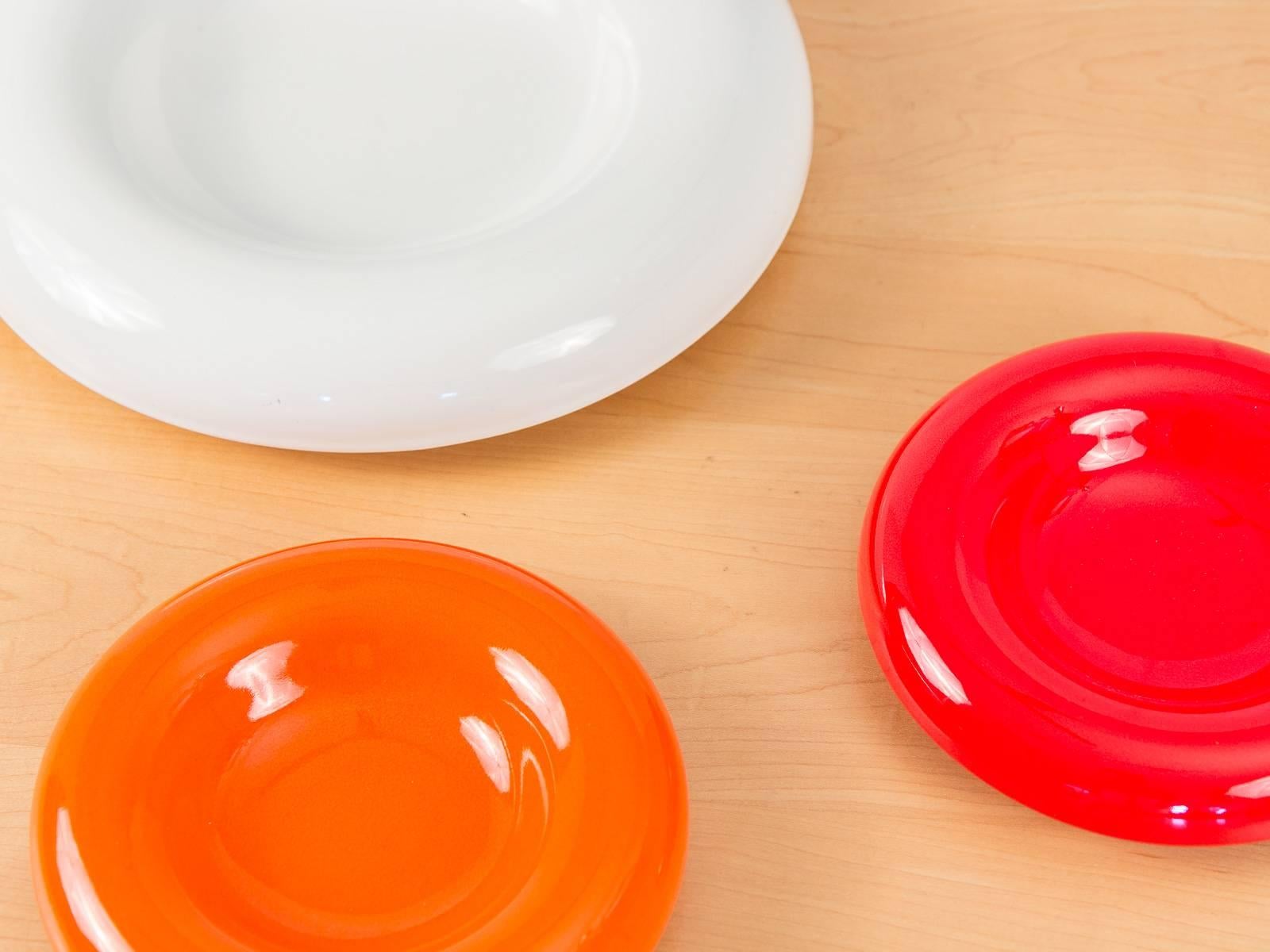 Three bold, mod 1960s ceramic plates with shallow center and rounded-wide rims for Sicart. Marked “611 Italy” on the underside.

Small orange and red plates measure 8” in diameter, and the large white plate measures 12.5” diameter.