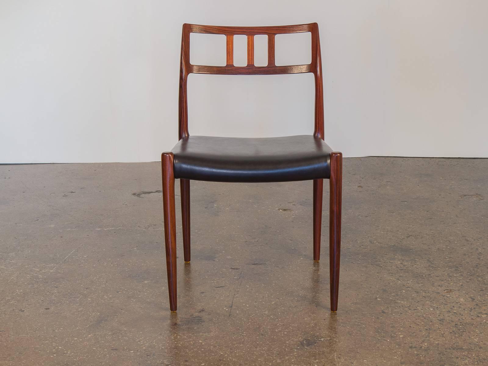 We have a rare, large quantity of twelve Møller Model 79 dining chairs by Niels O. Møller. Stunning, rosewood frames with distinct wood grain. Manufactured by J.L Møller in the late 1960s in Denmark. The black leather seats and rosewood chair frames