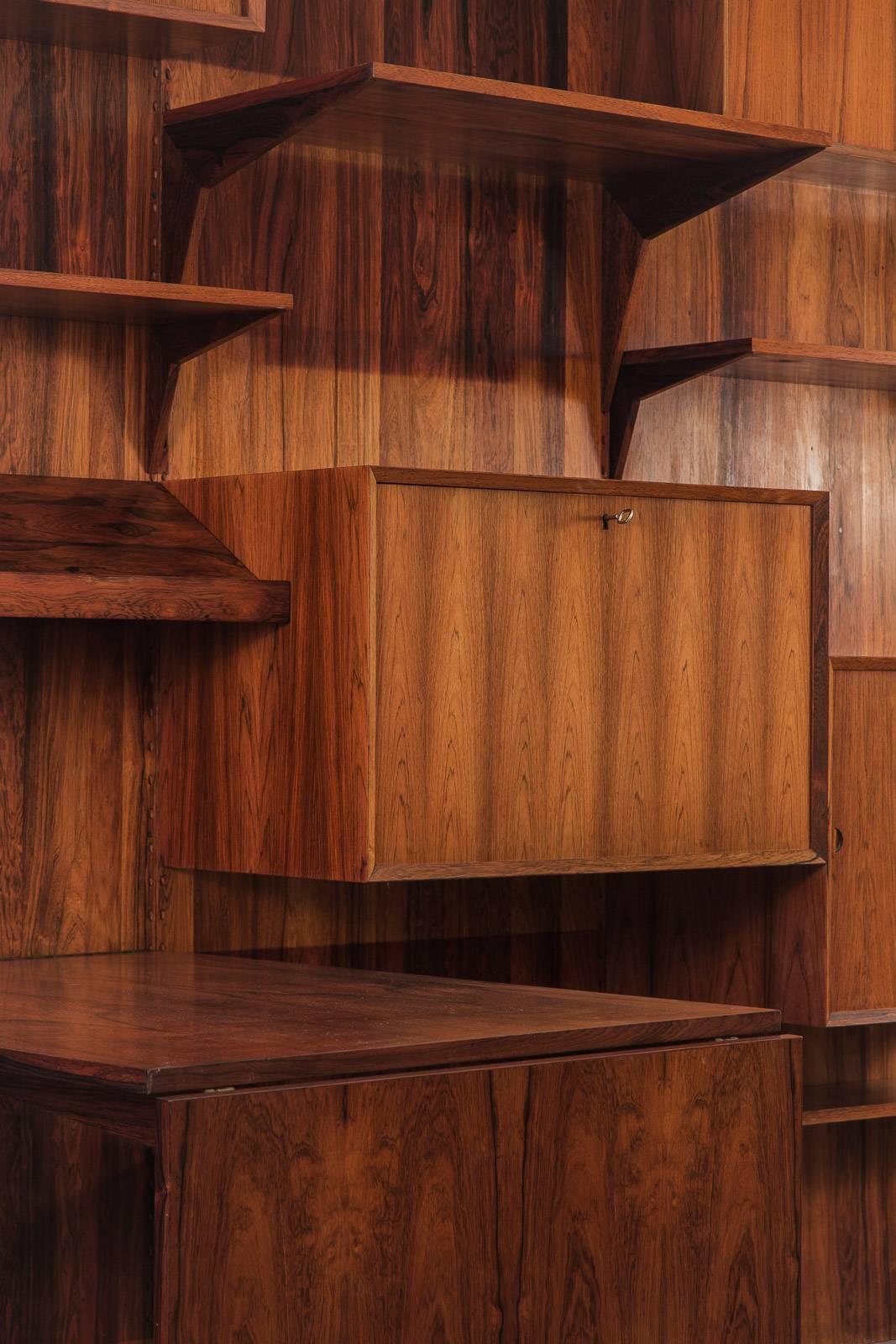 Monumental, modular wall unit from the 1960s by Poul Cadovius for Cado. Our version is impressive in size as it is in craftsmanship; the exquisite rosewood selection is evident throughout the shelves and detachable cabinet units. Wooden pegs are