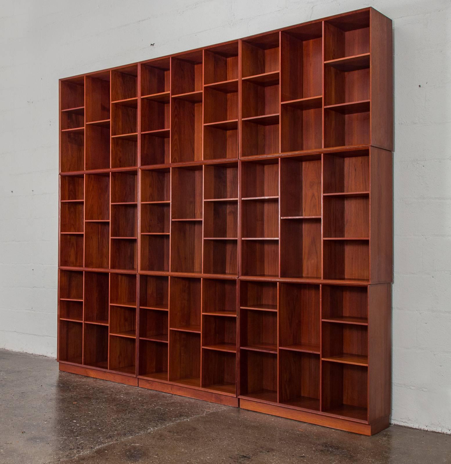Incredible wall of stacking bookcases in gleaming teak designed by Peter Hvidt and Orla Mølgaard-Nielsen for Søborg Møbelfabrik. Bookcases are constructed with beautiful, solid box joinery and adjustable shelves for total customization. Vertical