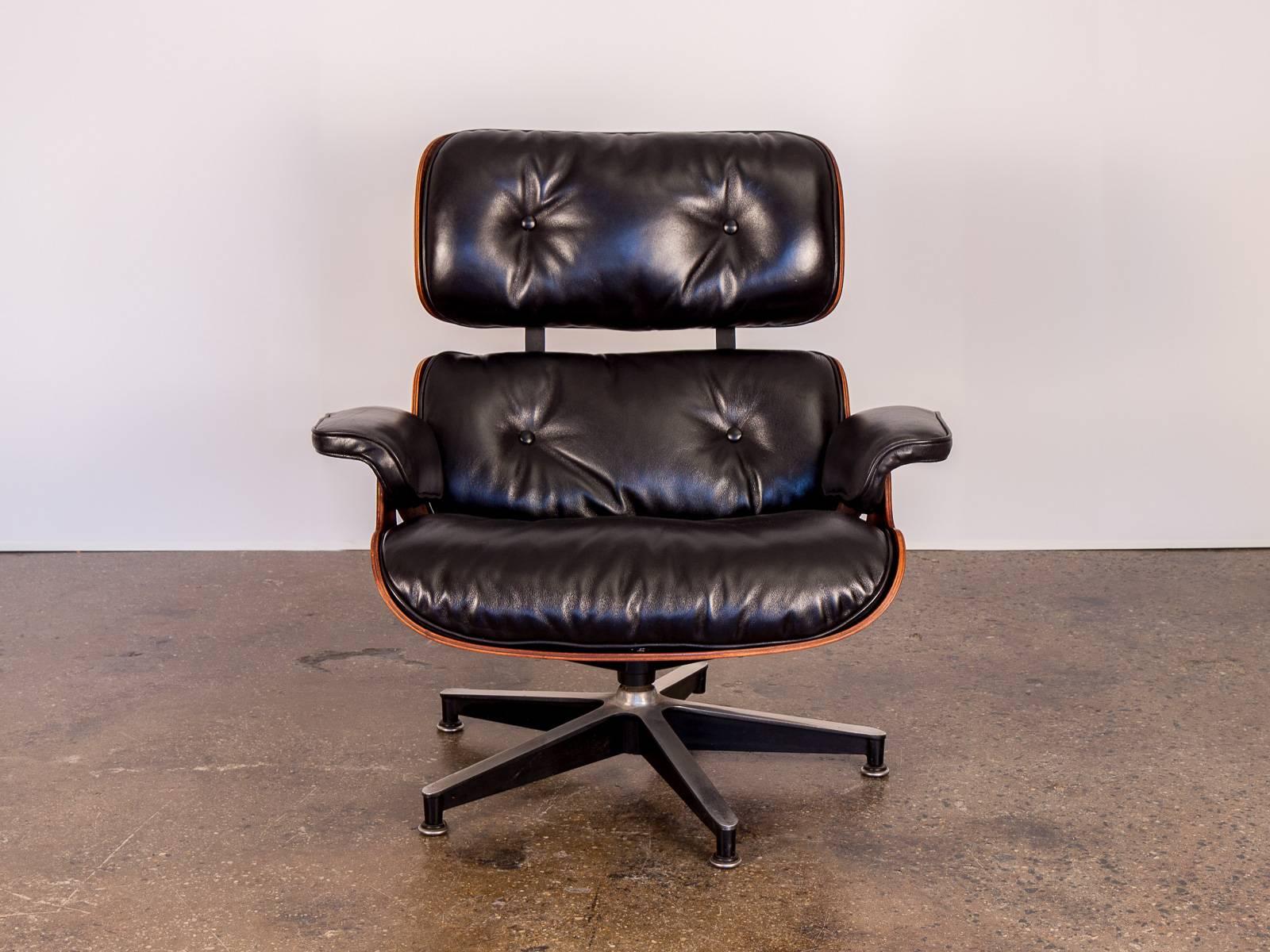 Timeless 670 Eames lounge chair and matching 671 ottoman by Charles and Ray Eames for Herman Miller. Lounge chair and ottoman have been fully restored with newly upholstered, sumptuous black leather and refreshed down cushions. Dramatic Brazilian
