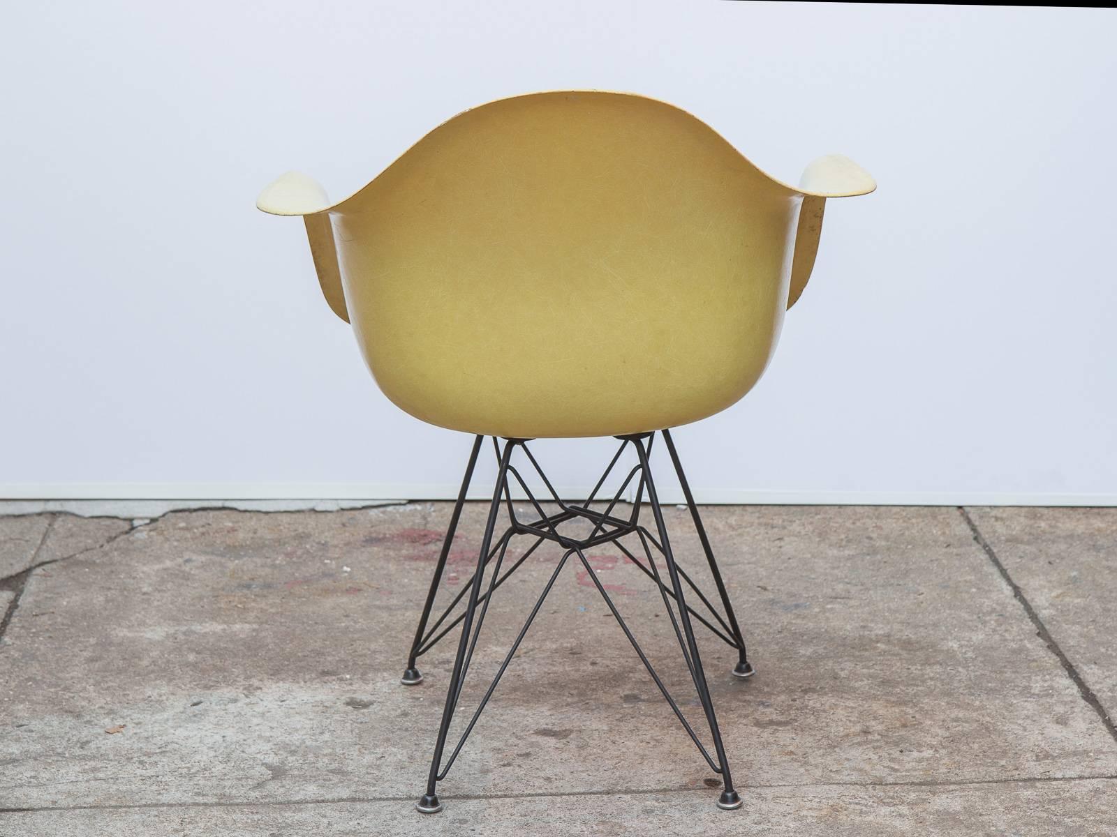 Classic Charles and Ray Eames molded fiberglass armchair in lemon yellow on the black Eiffel base for Herman Miller. Original finish with distinct thread texture. Herman Miller stamp on the underside. Other colors and base styles available, inquire