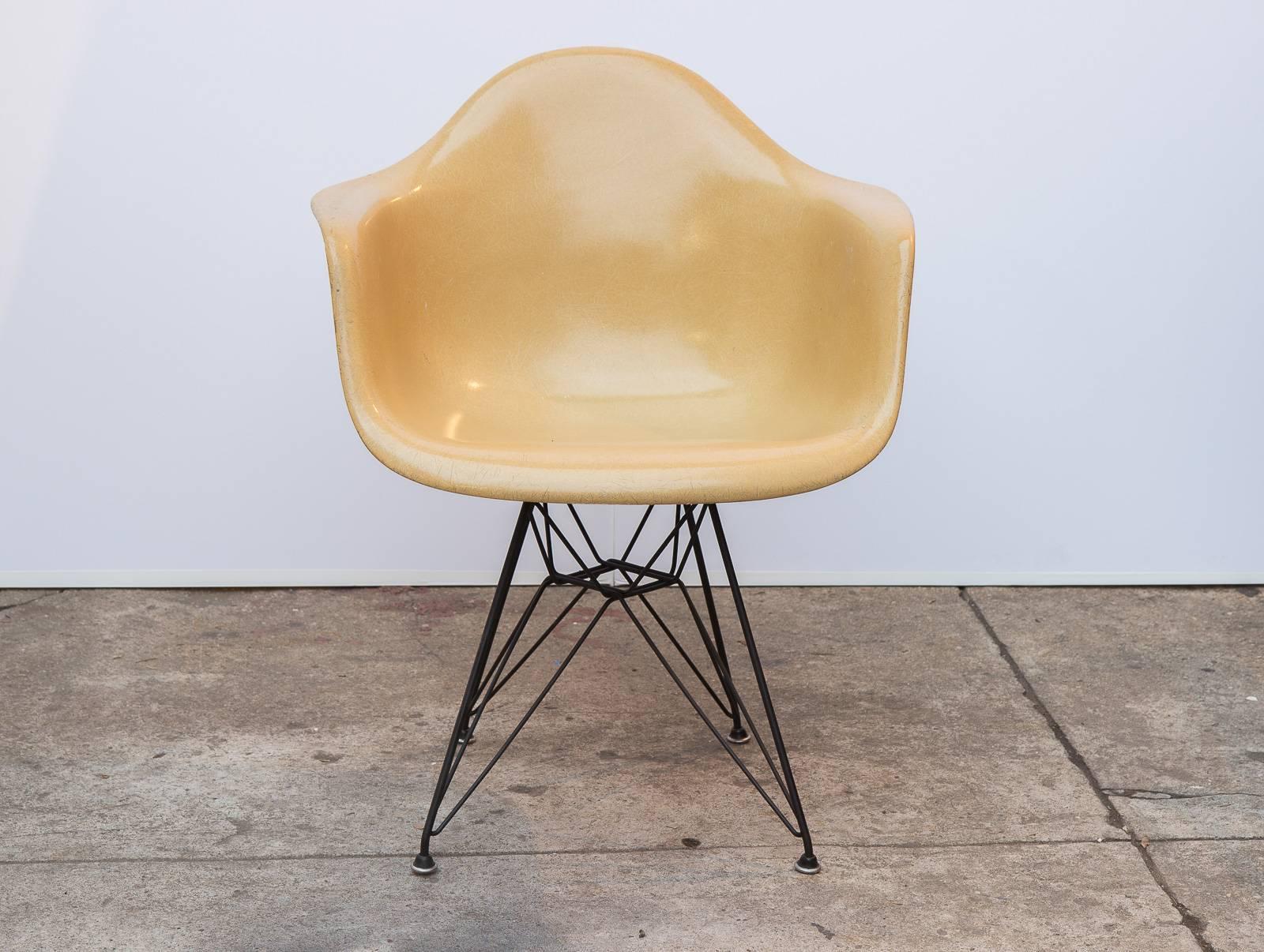 Original 1960s molded fiberglass armchair on black Eiffel base, designed by Charles and Ray Eames for Herman Miller. In a gorgeous butterscotch yellow colorway, with distinct thread texture. Finish is in original condition.  Shown here mounted on
