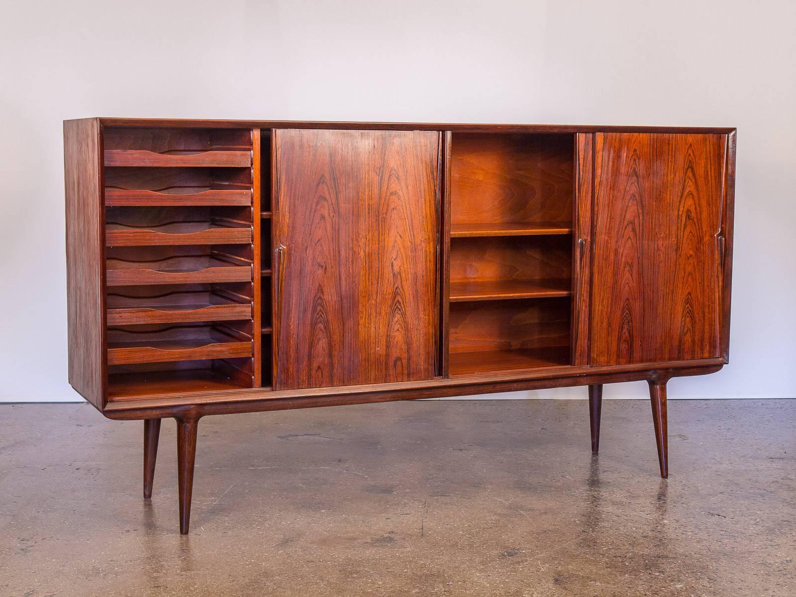Tall, Scandinavian Modern 1960s Brazilian rosewood credenza by Omann Jun Møbelfabrik. A brilliant option for storing, organizing, and entertaining. Measures: Standing at 43.5 inches high, this robust sideboard has four cabinets for ample storage