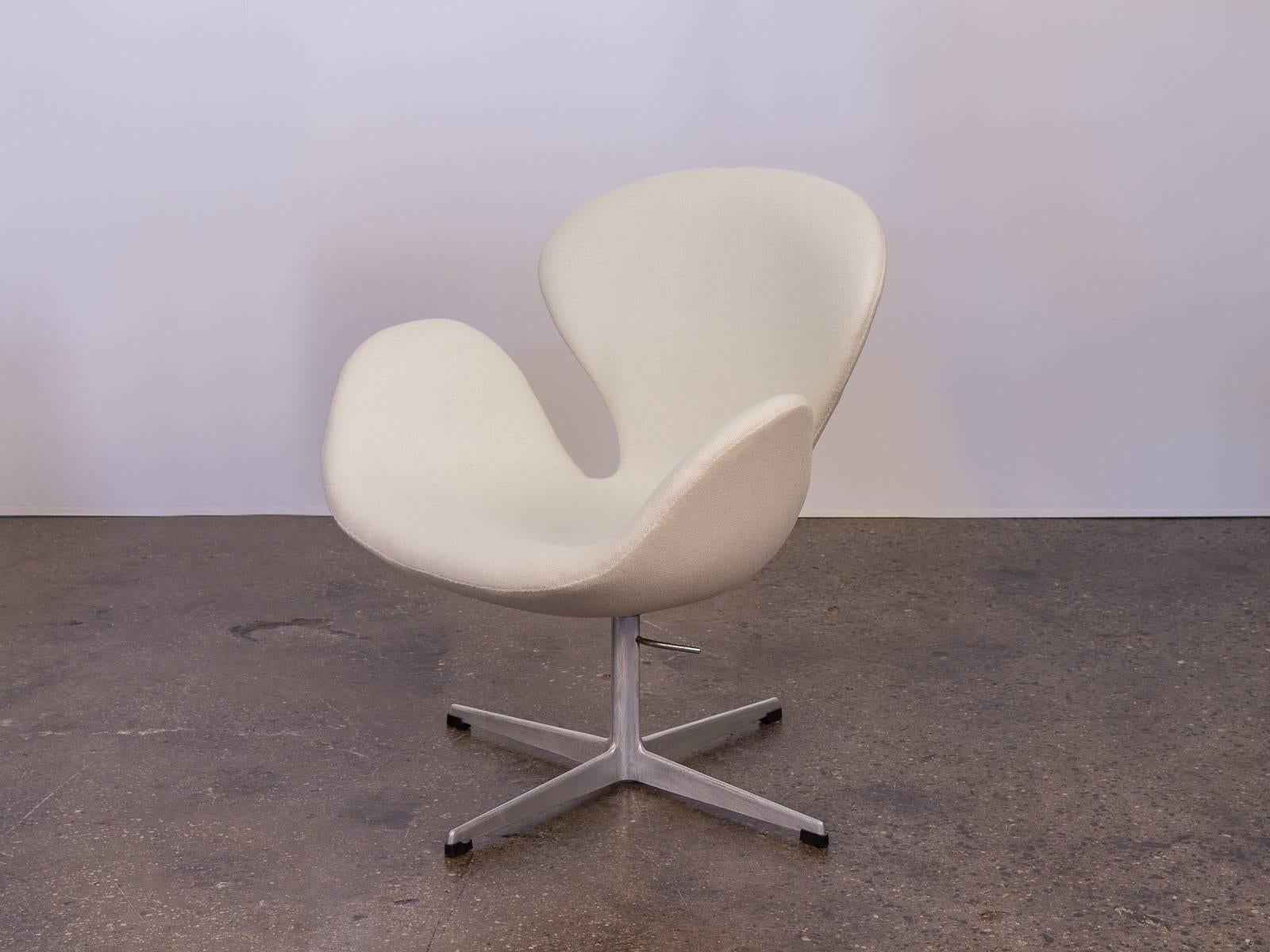 The iconic Swan chair designed by Arne Jacobsen in 1958. Attractive, ergonomic curves designed to sheathe it's sitter and follow resting limbs. Acquired from the original owner who purchased in the early 1960s. Meticulously upholstered in a creamy