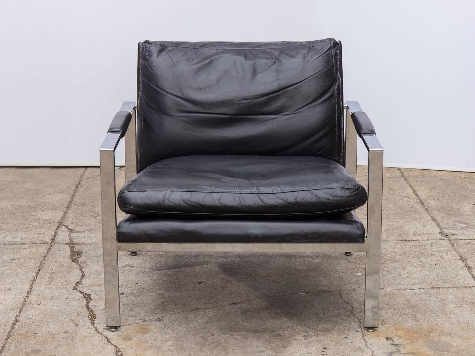 Black leather chrome armchair by California native Milo Baughman for Thayer Coggin. Comfortably plush cushions and arm pads are lovingly used the leather is soft to the touch and in good condition with no tears or holes. The solid flat-bar chrome is