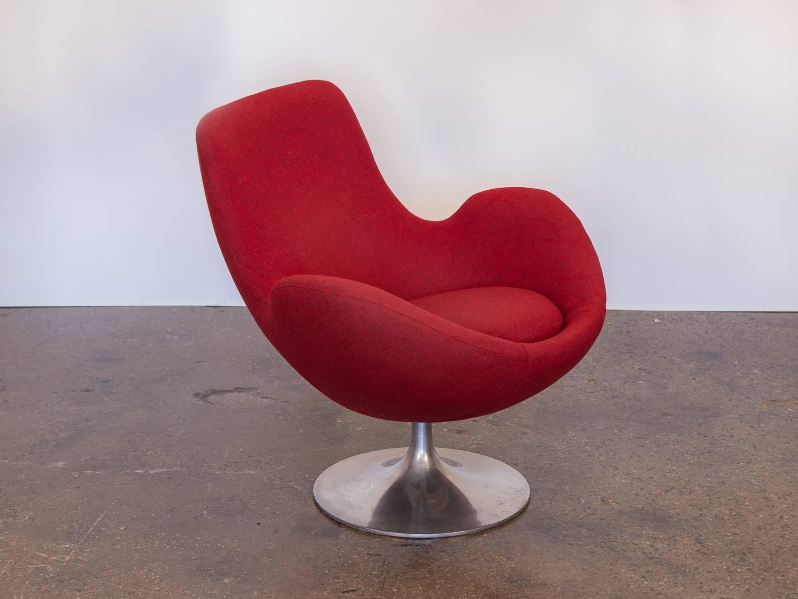 Scandinavian overman-style swivel chair. This stylish lounge chair has a sculpted tulip back that slopes into raised armrests. The body of the chair cradles like a pod for maximum comfort. Cushions are robust, and have been newly upholstered in a