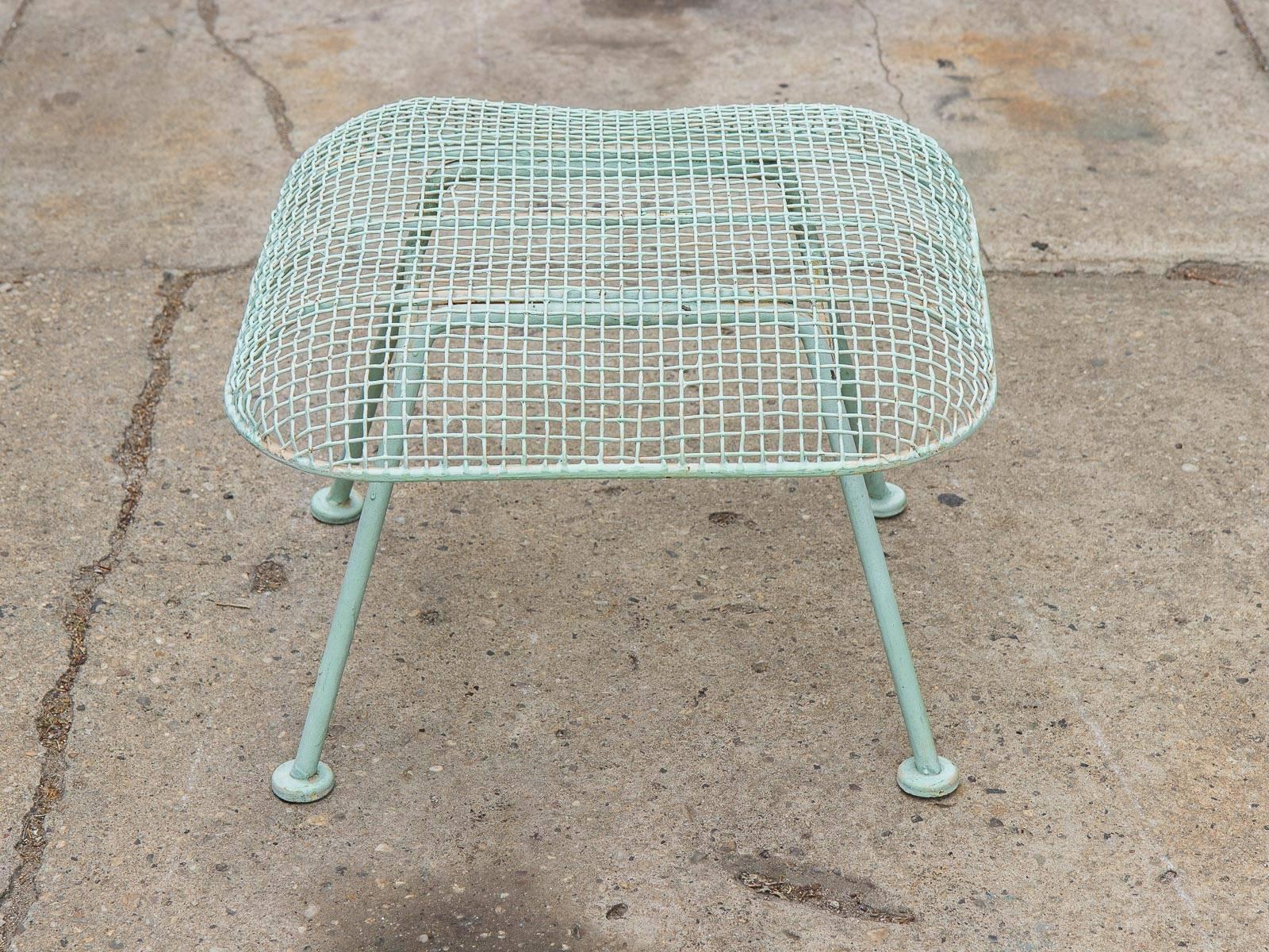 Scarce, Russell Woodard Sculptura wrought iron outdoor ottoman. This example is from the 1960s, and is in great vintage condition with some age-appropriate wear and chipping to the paint. The iron mesh has been painted a light, mint-teal giving it a