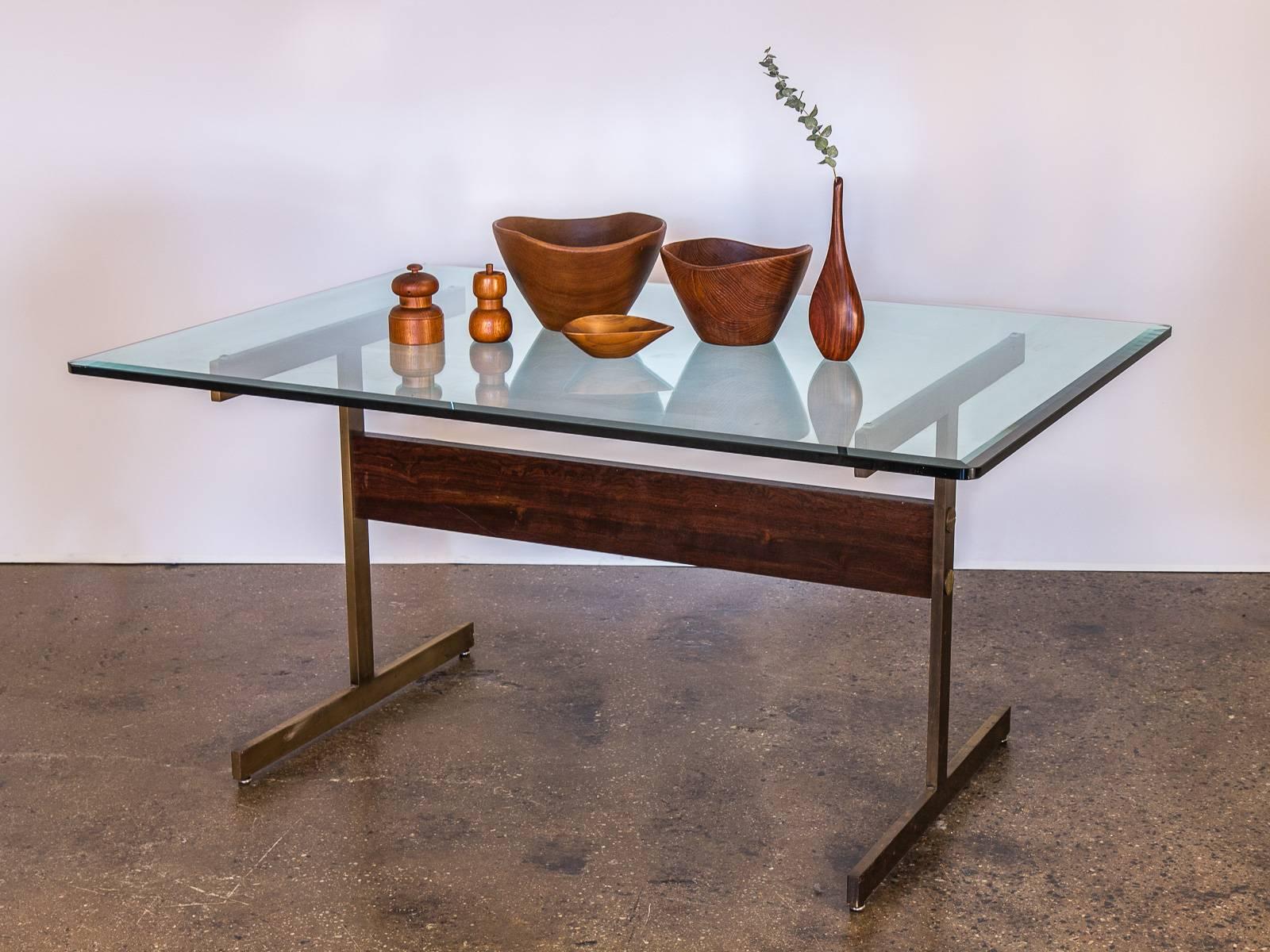 Stunning, minimal Milo Baughman glass table on brass pedestal base for Thayer Coggin. The substantial, 1-inch thick glass sits on a seamless flat bar, brass H-base featuring a gleaming rosewood beam support. Bewitching cerulean-tinged hue follows