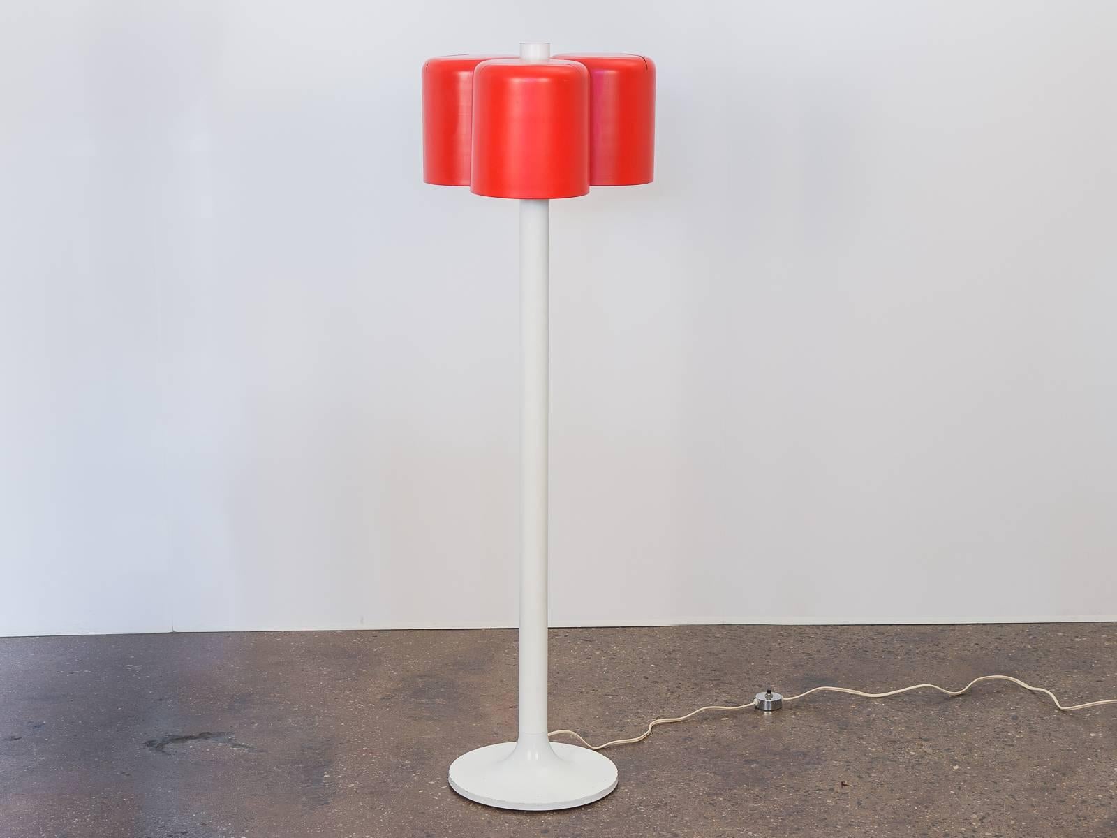 Space Age floor lamp by Nessen. Reminiscent of Joe Colombo's Coupe lighting series. In perfect working condition. Three cylindrical vermilion painted shades are fixed to a white enameled neck that smoothly curves to form a circular base. Label