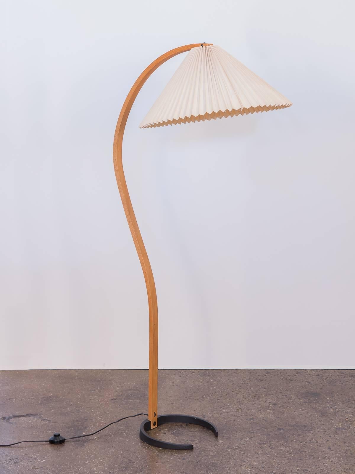 1970s bentwood floor lamp by Mads Caprani. Original linen pleated shade is in very good vintage condition, with no rips or tears. Works beautifully. Cast iron, crescent base is stamped with the Caprani name. A playfully sophisticated,