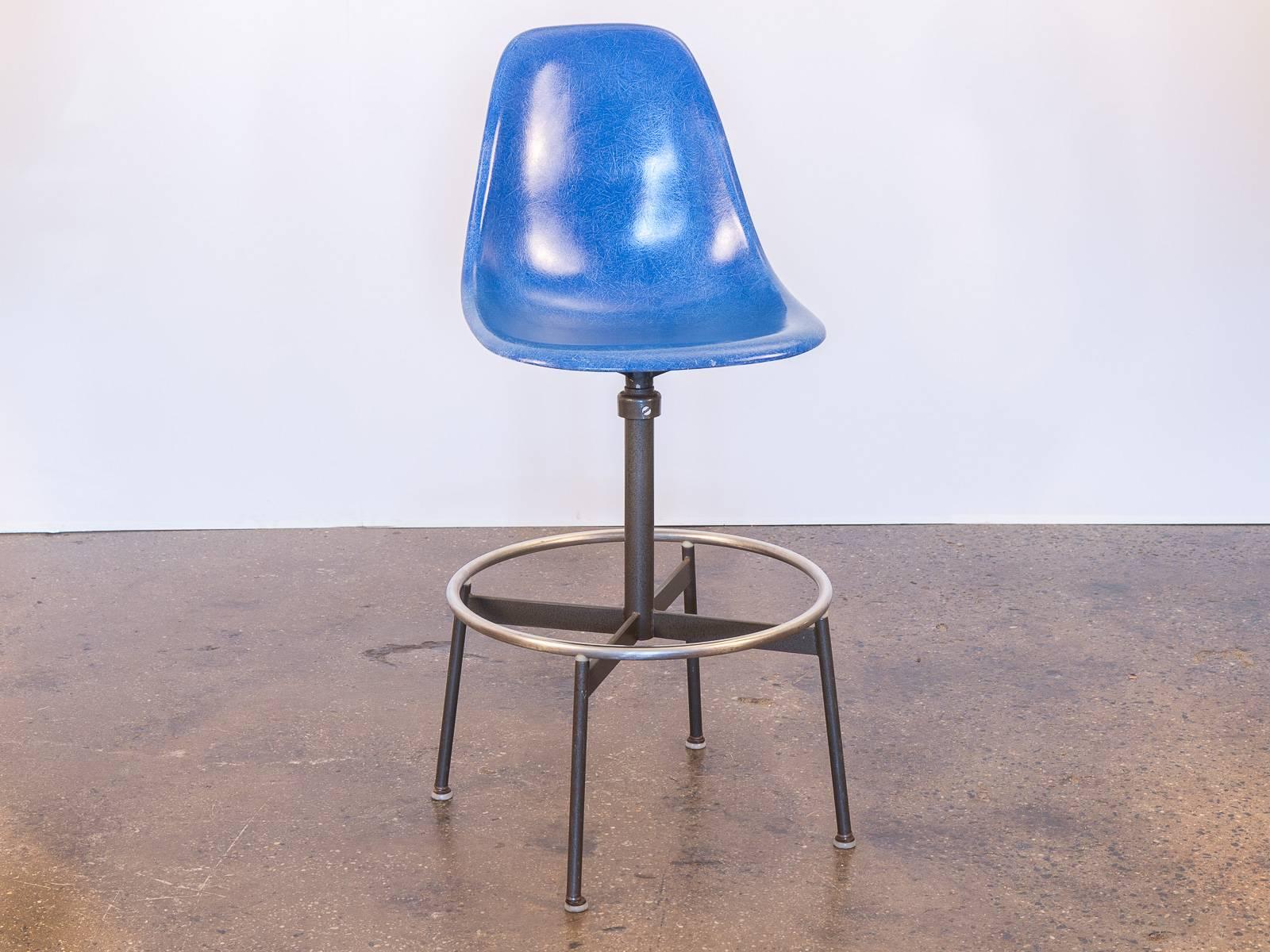 We have a gleaming Eames blue fiberglass shell chair on an original Herman Miller drafting swivel base. Sleek, Classic drafting stool for work or home office. Solid metal base in is excellent condition, with all original glides. Other shells are