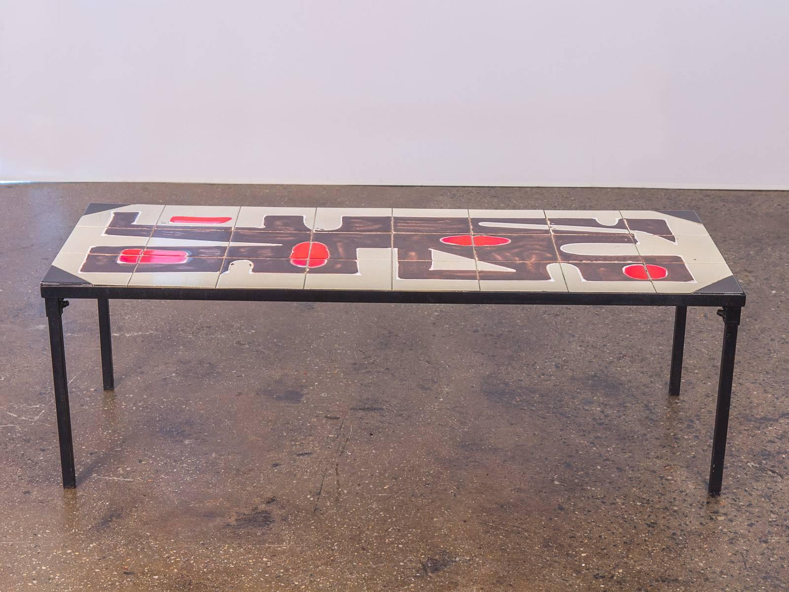 Belgian tile-top coffee table. Beautiful Mid-Century Modern coffee table with inlaid ceramic tiles. Vibrant, abstract illustration is reminiscent of Andre Borderie and Roger Capron. Black enamel metal frame. Excellent vintage condition. Made in