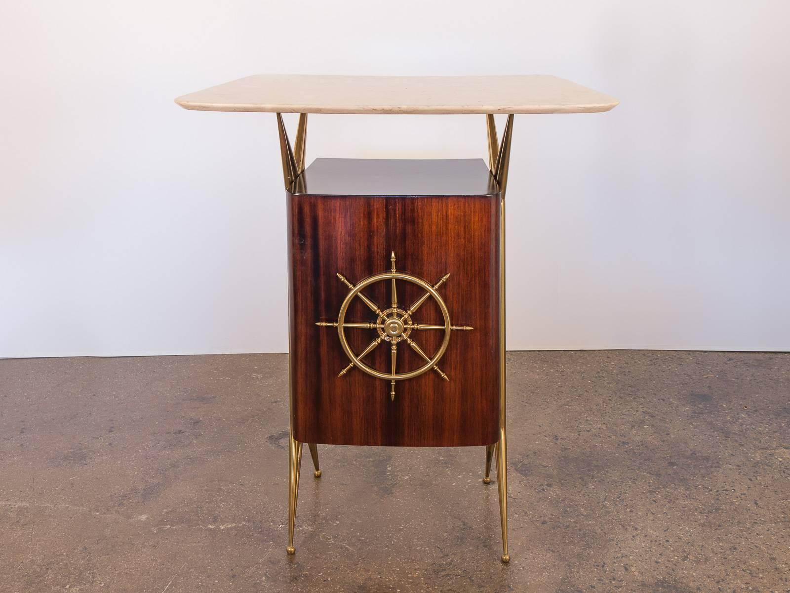 Effeminate, glamorous dry bar in the manner of Italian designer and architect Gio Ponti. Hefty, solid rounded marble counter-top sits on sculpted, jaunty brass legs. The rounded rosewood veneer cabinet adorns a charming nautical wheel on the front,