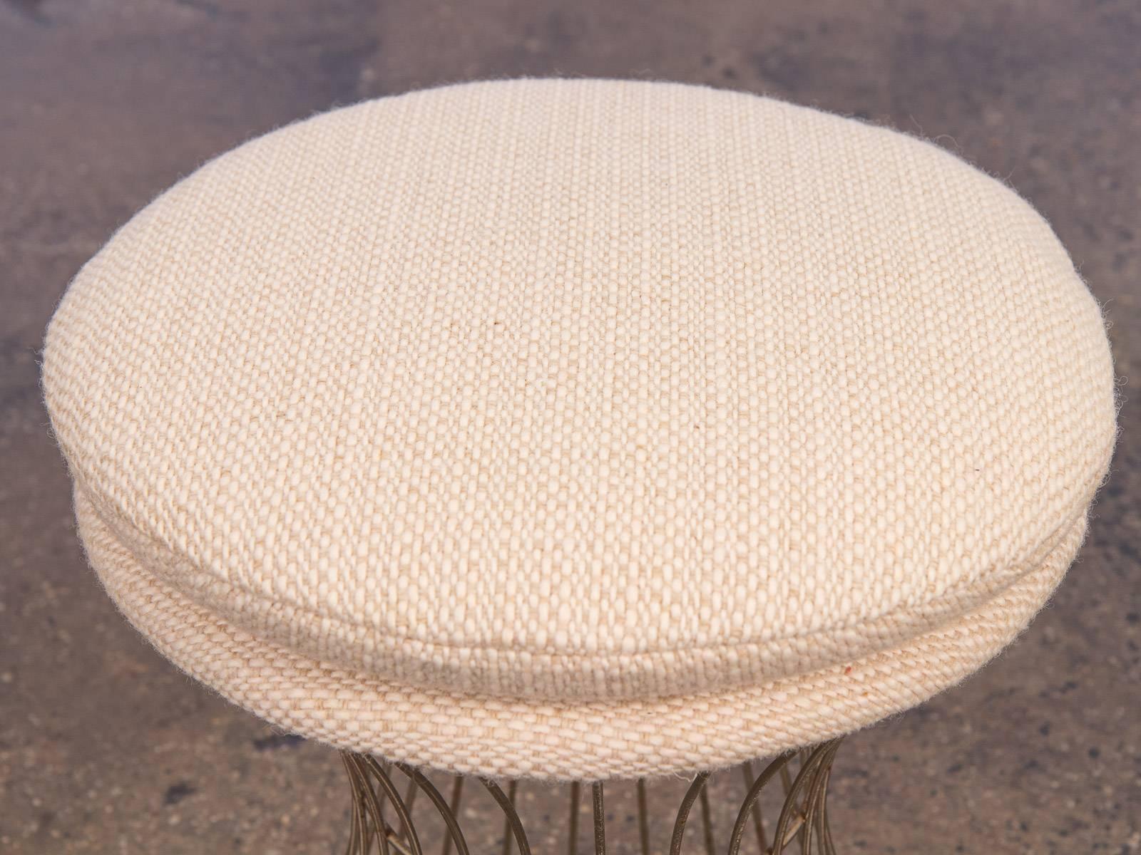 Vintage wire stool in a creamy, textural wool in the manner of Warren Platner. Excellent condition. The plush seat cushion has been newly replenished and upholstered. Gracefully perched on a 1960s, airy, steel wire base. Minimal design and compact