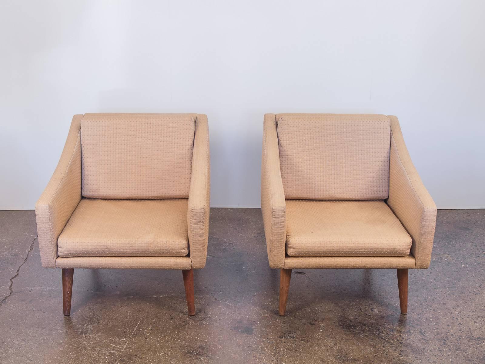 Pair of vintage, modern club chairs. Form is attractive, with subtly sloping armrests and deep seats making them an ultra comfortable pair of lounge chairs. Cushions are cozy with plenty of life and the tapered poplar legs are trim and sturdy. Sandy