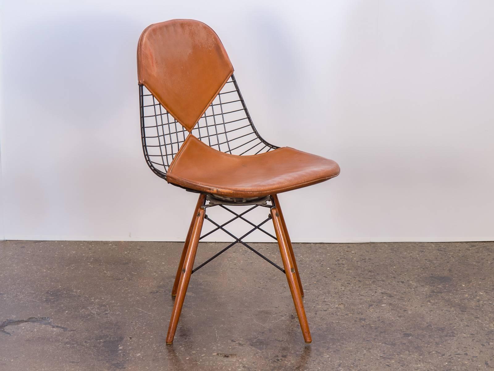 Scarce, original, 1950s Eames PKW2 wire chair on walnut dowel swivel base for Herman Miller. One of the finest Eames PKW2 chairs we have had at OAM. Bikini leather patina is beautiful, lined woven fabric is not dried out or brittle but is soft and