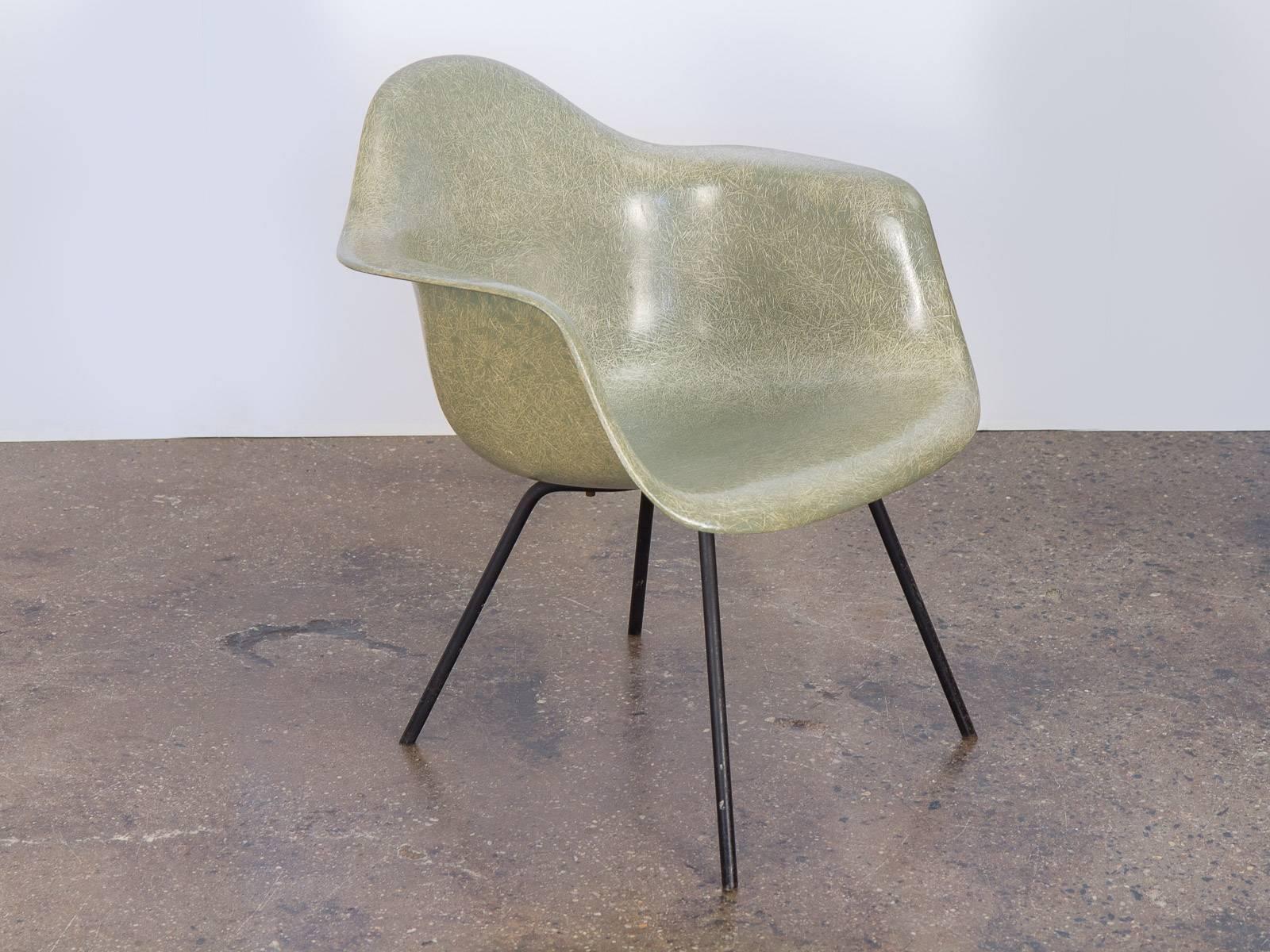 Very scarce, Second Generation Eames Armshell chair in the covetable seafoam hue on an early black steel X-base. Excellent condition. Original 1950s finish. Incredibly distinct thread, giving the surface a striking texture. Molded fiberglass is