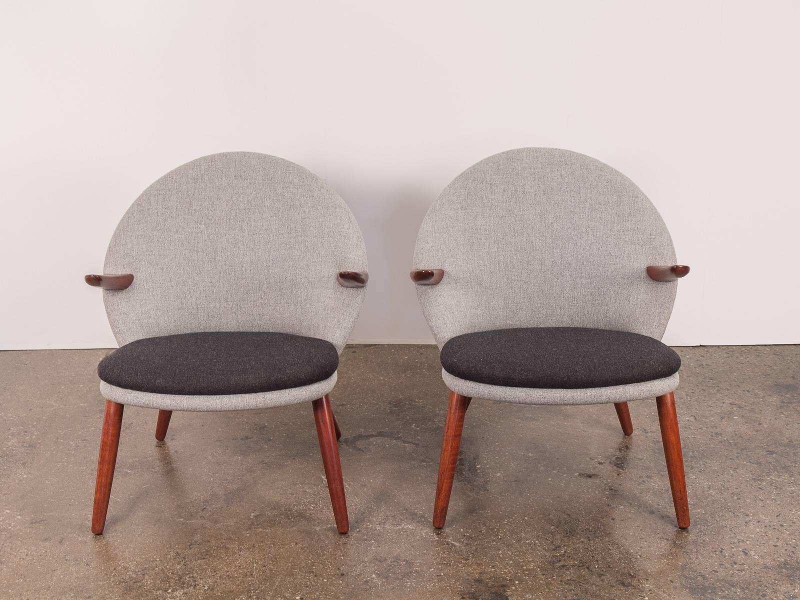 Unusual pair of easy chairs by Kurt Olsen for Glostrup Mobelfabrik. These chairs have been fully restored. The form boasts a continuous profile that is organic and sculptural — the new Maharam Tonica upholstery follows every curve and bend. Teak