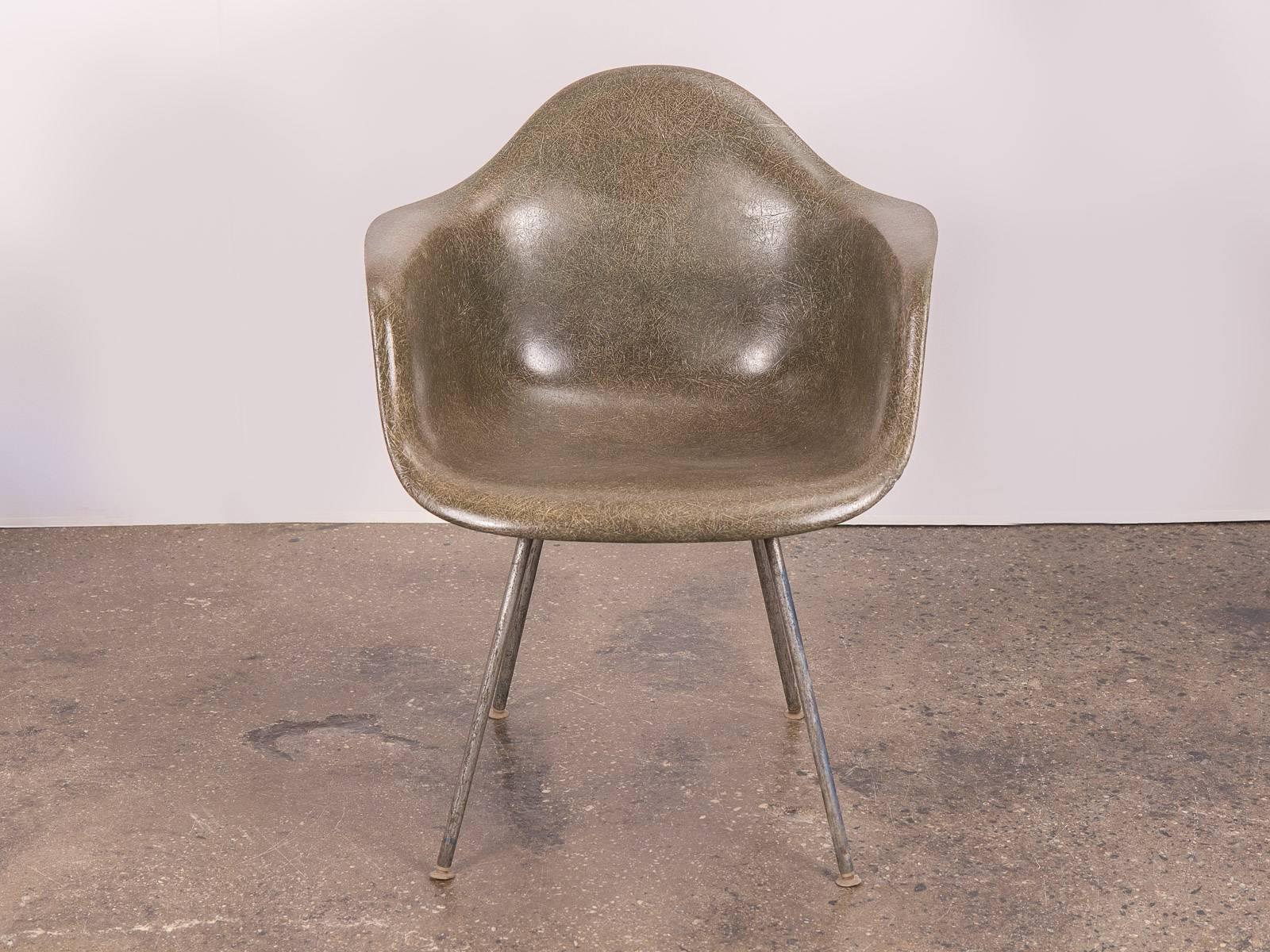 Vintage Eames molded fiberglass armchair in the scarce, olive green hue on a the nickel H-base for Herman Miller. Original finish with distinct thread texture that varies in saturation and density throughout the chair. Excellent vintage condition