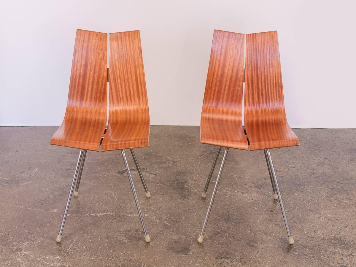 Pair of Hans Bellmann GA Dining Chairs for Horgen Glarus designed in 1955. Two parallel panels of moulded birch plywood has a striking nutwood veneer that curves to form this chair design, subtly tapering off at the seat edge. Elegant simplicity,
