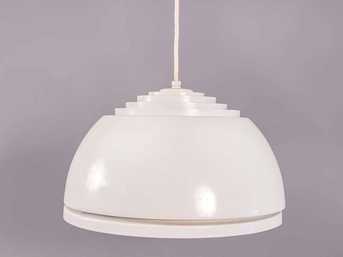 1960s Louvered lightolier dome pendant lamp in the manner of Verner Panton. Sleek white enameled form features staggered concentric circles allowing passing light to escape. A glass cover helps diffuse and distribute even light below. Some