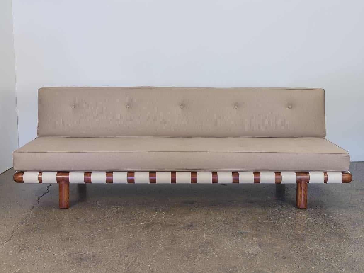 Incredibly rare T.H. Robsjohn-Gibbings sofa model 1711 for Widdicomb. Newly upholstered in a neutral palate that is attractive and versatile. Freshly woven cotton webbing in a bright ivory hue compliments the dark walnut sculpted frame, which has