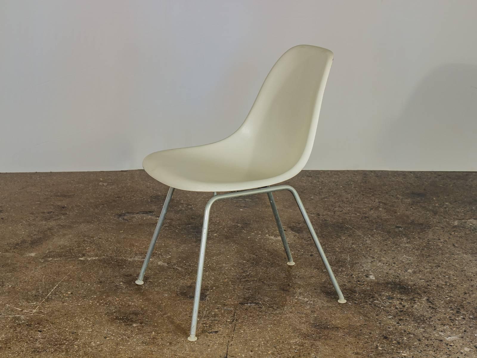 Original 1960s molded fiberglass shell chairs in white, designed by Charles and Ray Eames for Herman Miller. Gleaming shells are in original condition, each with a distinct thready texture.  Shown here mounted on vintage H base, additional base
