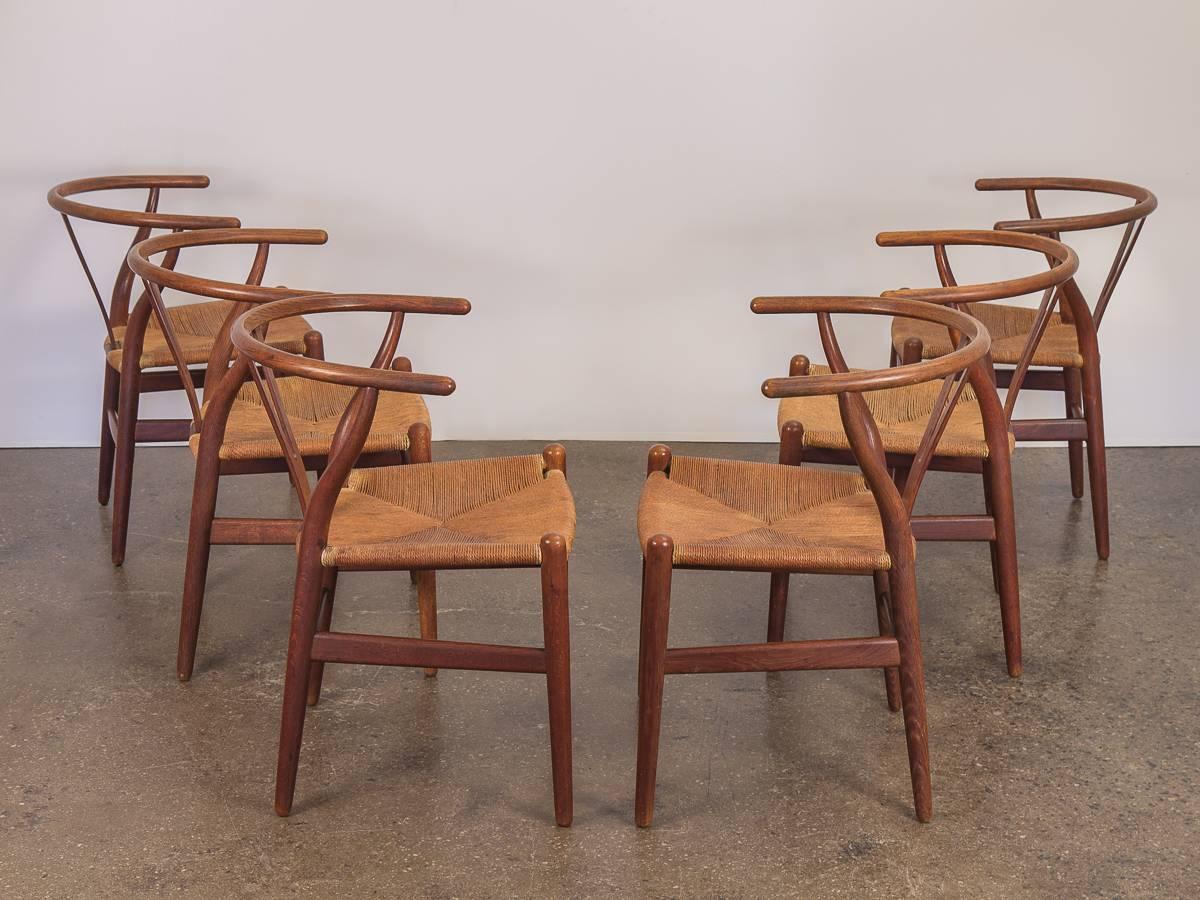 Set of six Hans J. Wegner wishbone chairs produced by Carl Hansen & Son. These iconic dining chairs combine seasoned elegance with fine craft. First designed in 1949, our 1960s examples are in amazing vintage condition. Patinaed oak has aged nicely,