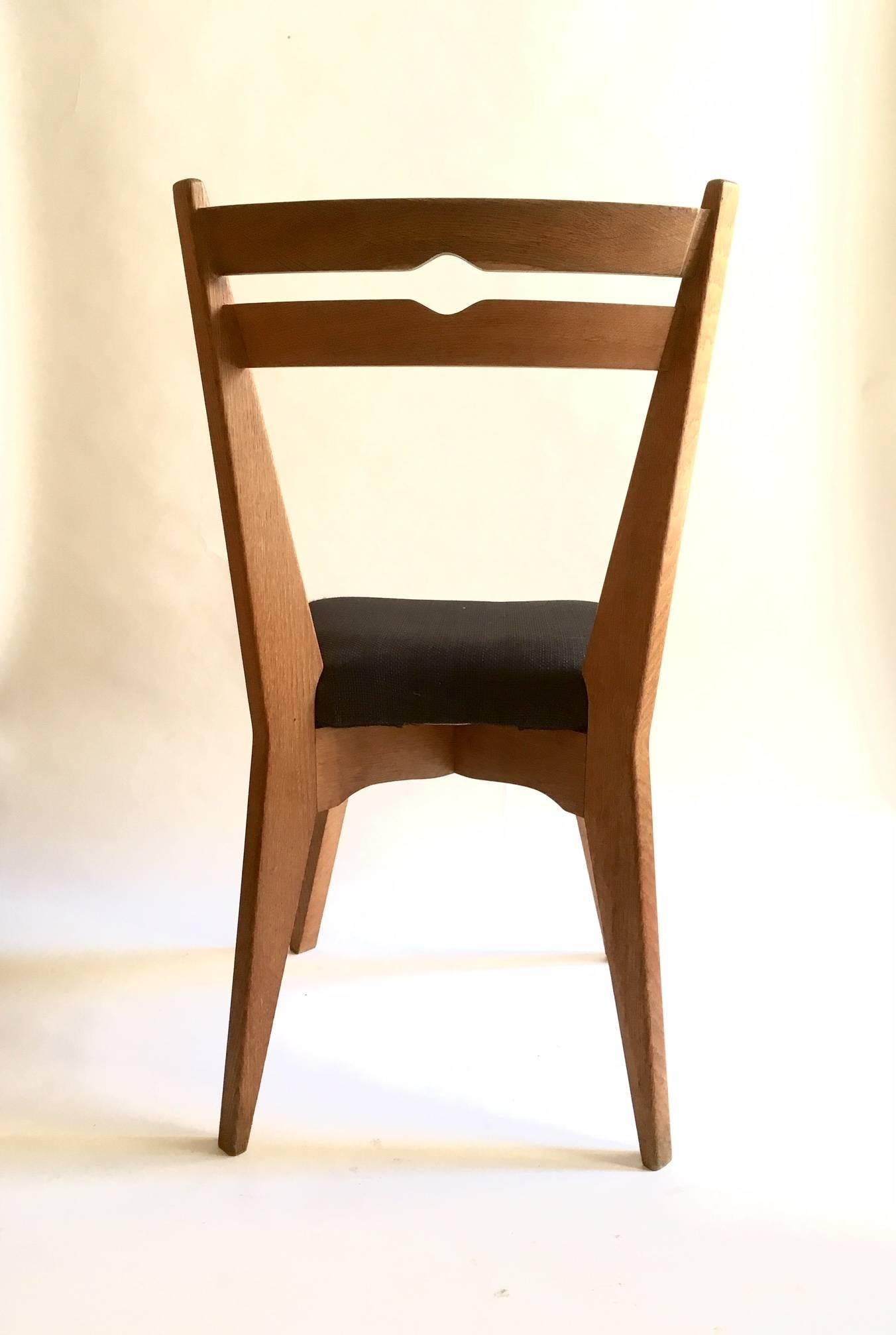 Set of six dining chairs with tapered angular legs in solid oak designed by Guillerme et Chambron.