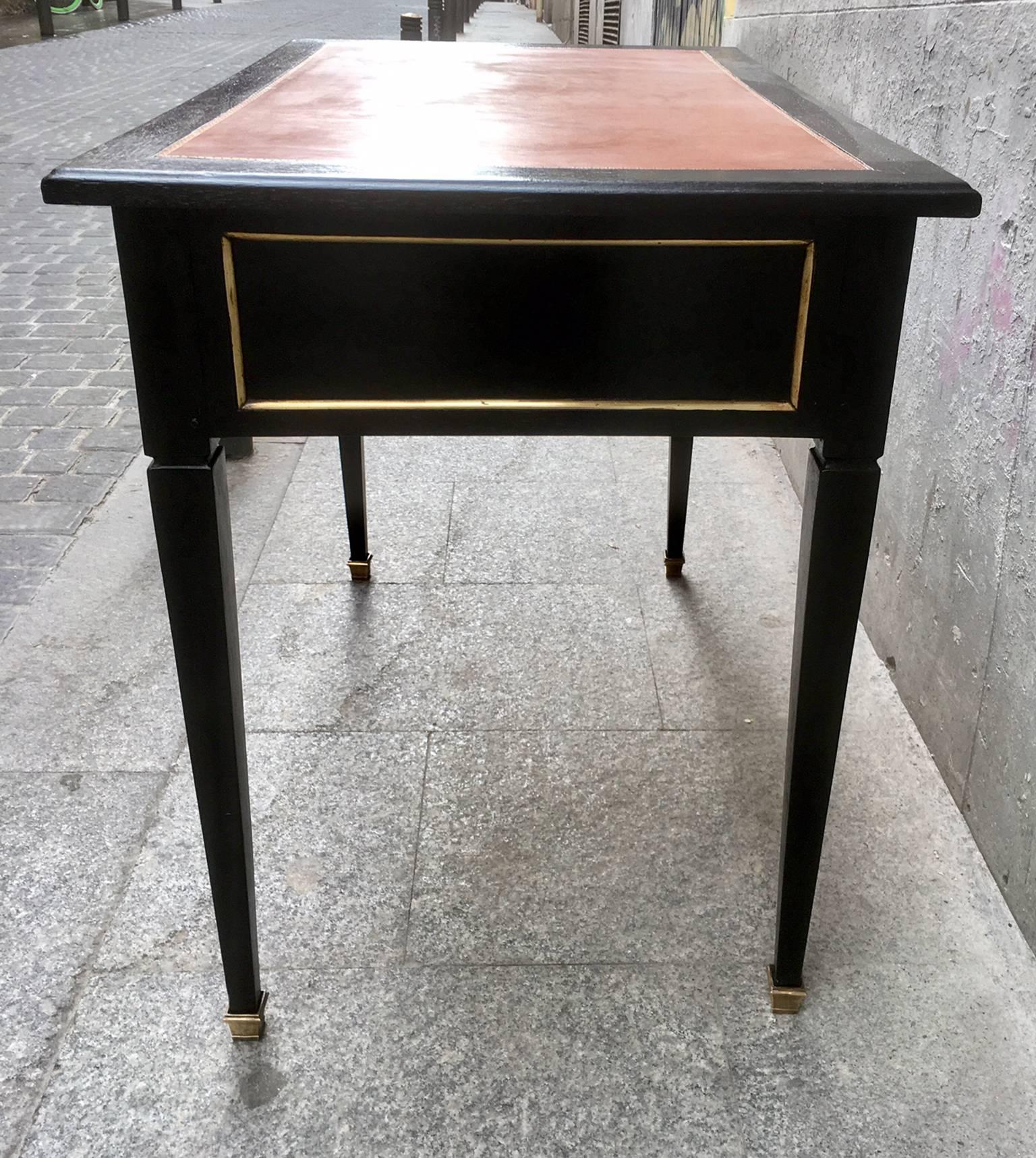 Table-desk ebonized French Louis XVI style with two drawers and red brown leather top and brass details.