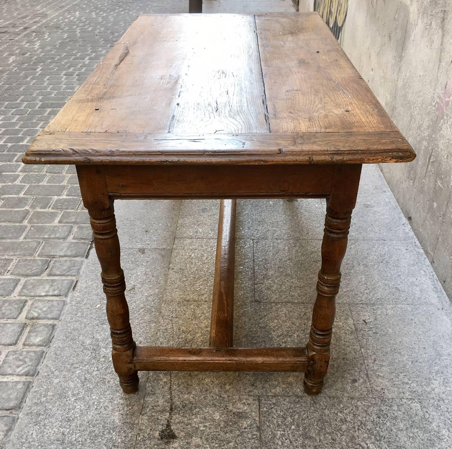 Rectangular oak 18th century country table with turned legs and a trestle base.