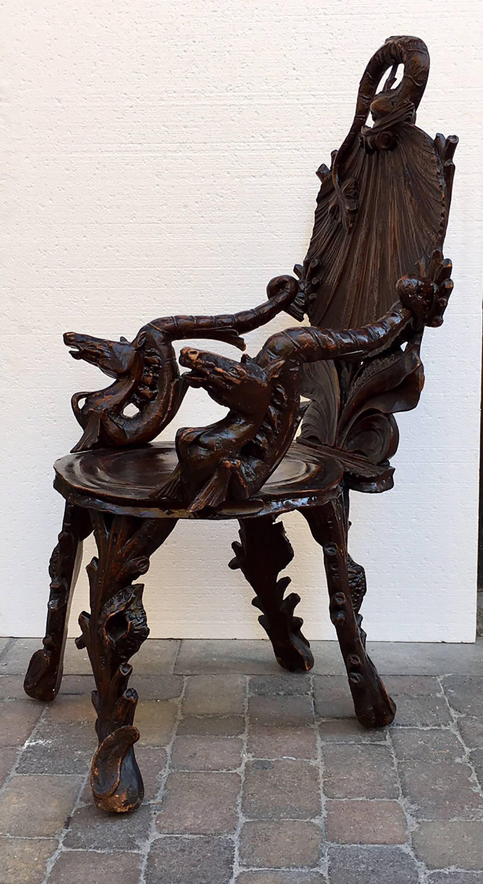 19th century Venetian walnut grotto style armchair with carved shell form seat, back with dolphin in top, carved arms in horse head forms.