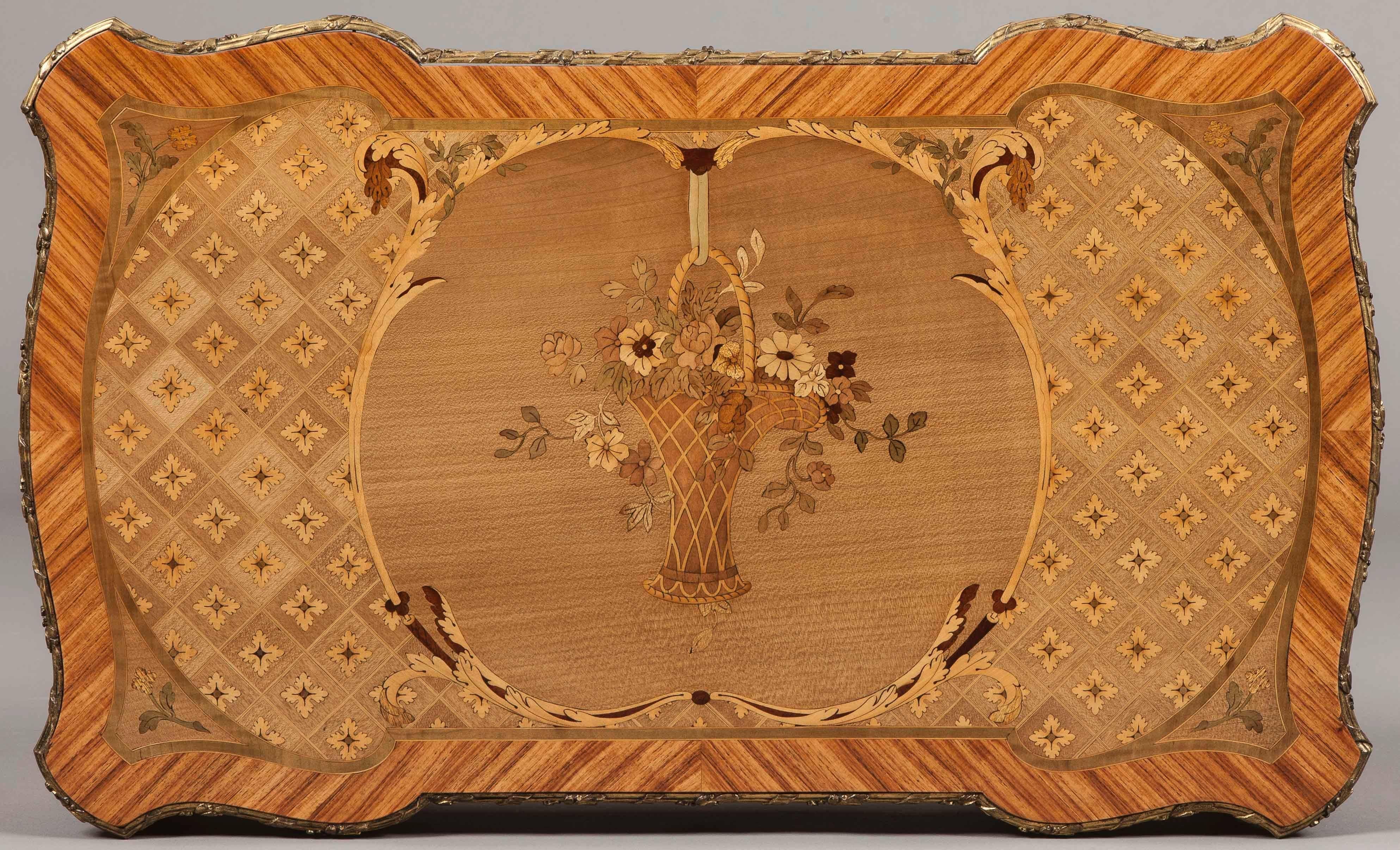 Un tavolino da salotto da donna in stile Luigi XV.

Di forma indipendente, costruito in legno di re, con buoni intarsi e con montature in bronzo dorato; si erge da gambe cabriole slanciate con sabot in bronzo a forma di foglia e spagnolette