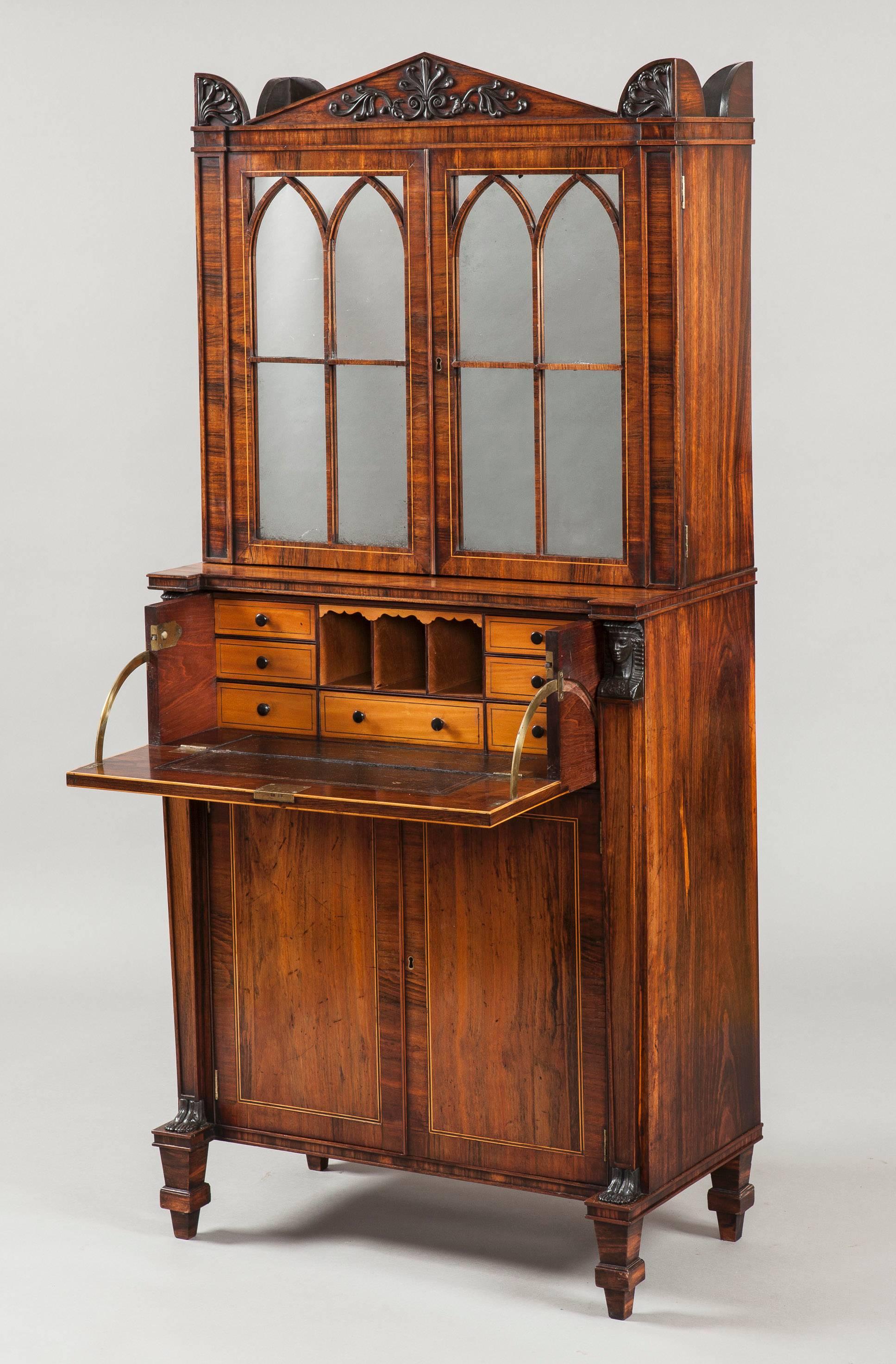 A secrétaire cabinet of the Regency period
Firmly attributed to George Oakley.

Constructed in a finely faded and patinated goncalo alvez, having holly and purple heart stringing; with satinwood to the secrétaire interior; rising from tapered