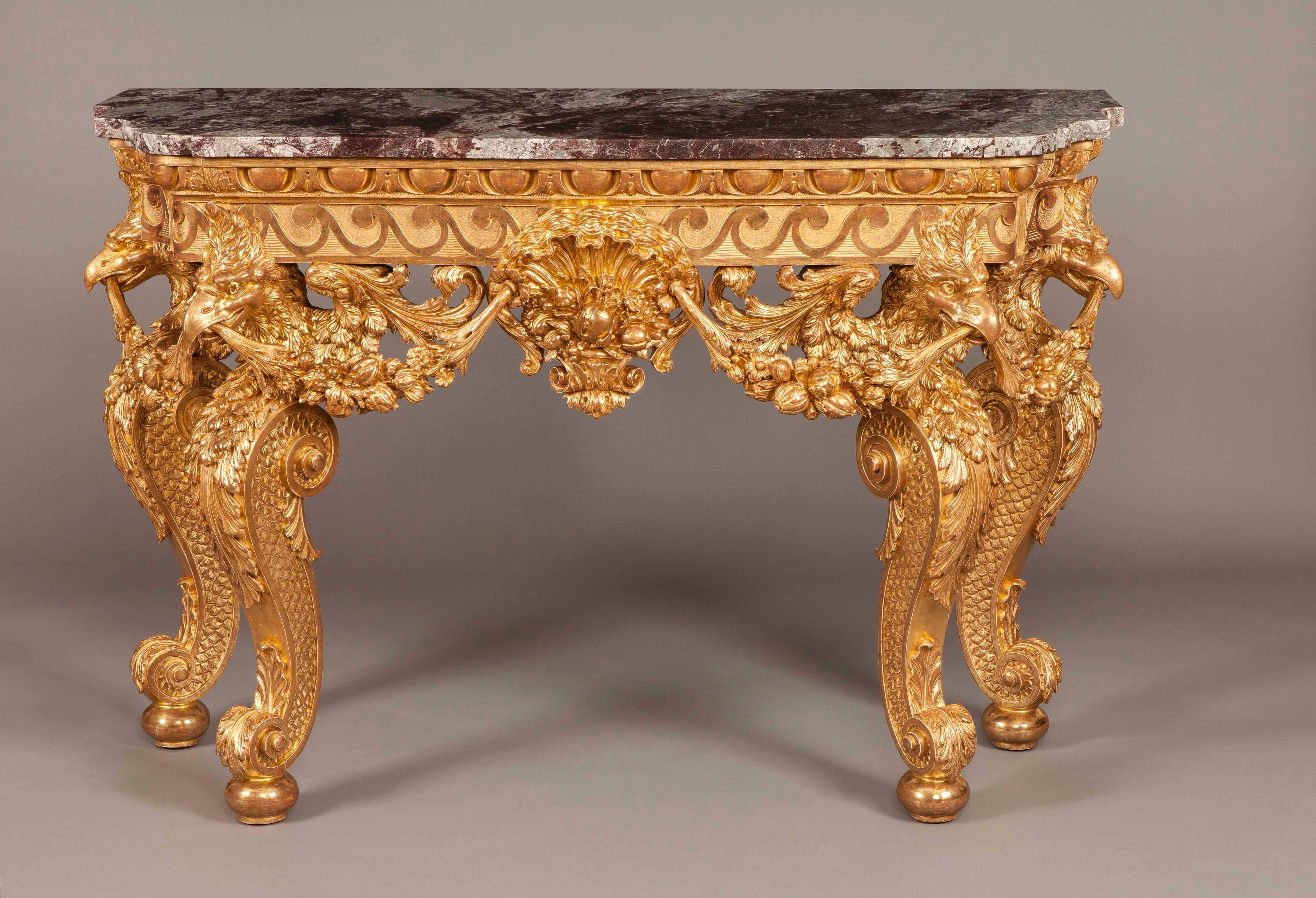 
Of arc-en-arbalette form, constructed in giltwood, with marble platforms. The swept and channelled legs rest on oblate bun feet, the toes and shoulders being adorned with oak leaves and a comprehensive imbricated pattern, terminating in eagle's