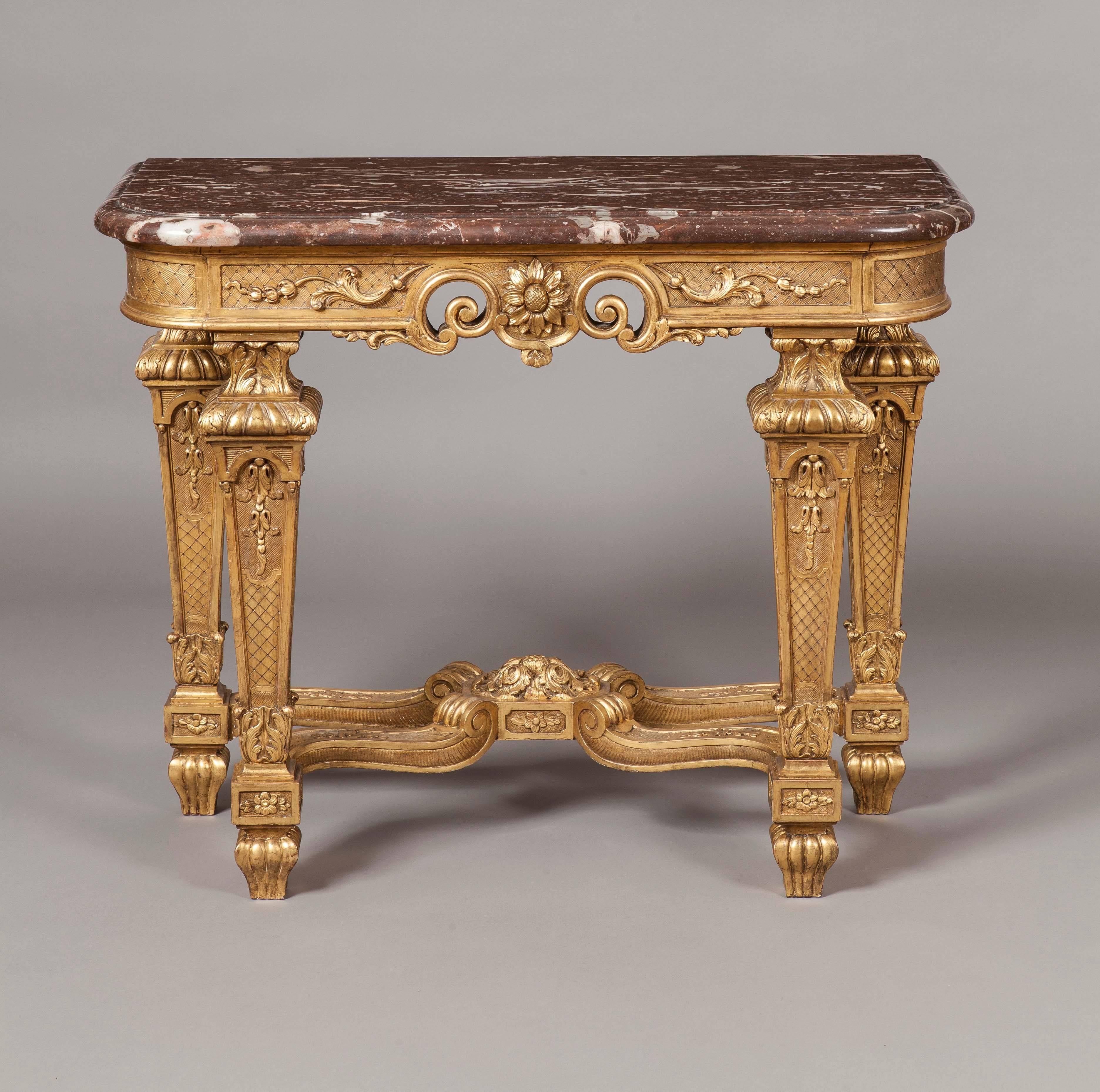 Constructed in giltwood, carved and decorated, with red griotte marble platforms; of rectangular form, rising from tapering channelled and collared legs decorated with pendant foliates and scrolls; the conjoined shaped ‘X’ form stretchers having