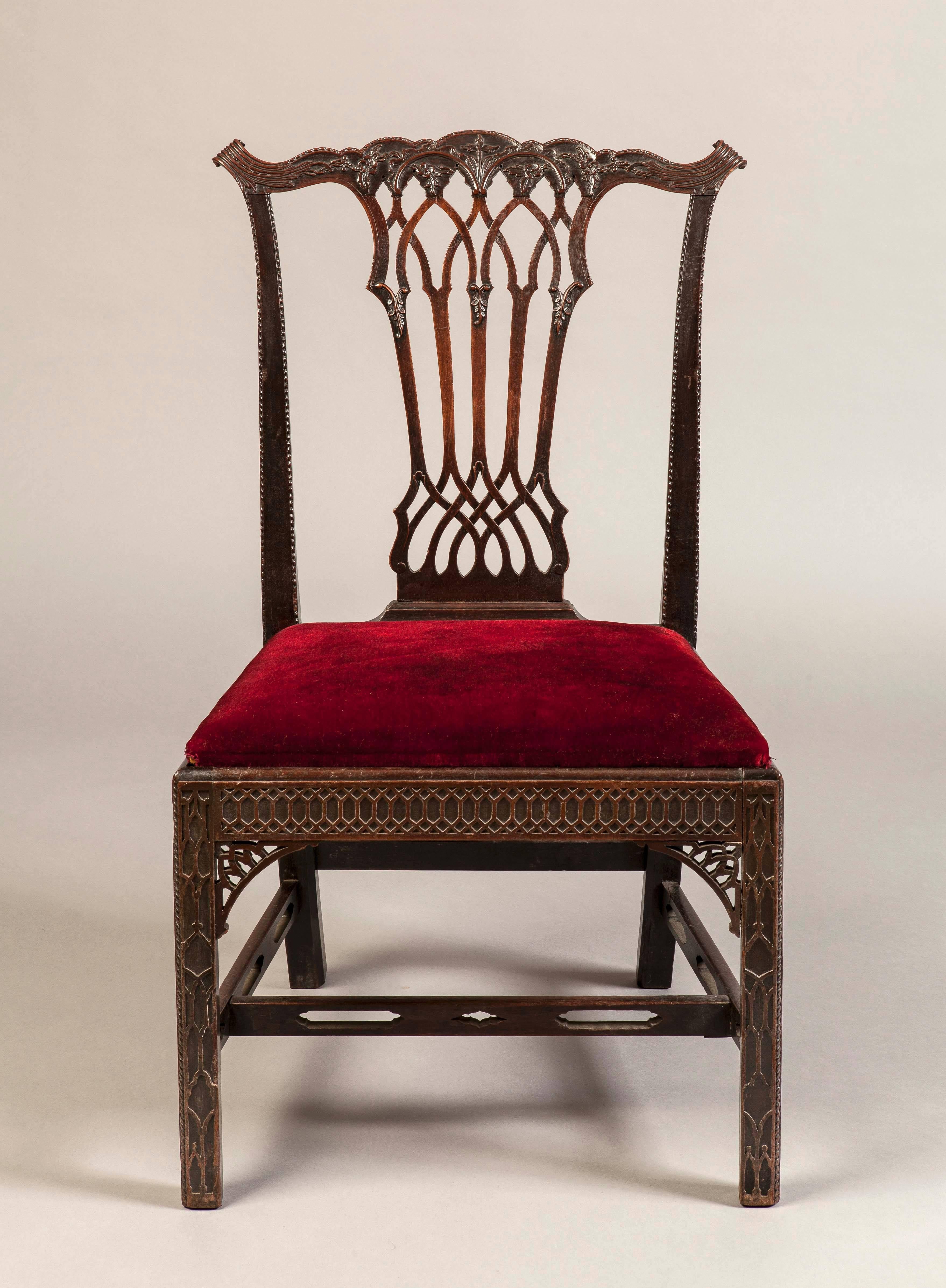 A Good Set of Eight Side Chairs in the Georgian Gothick Manner

Constructed in mahogany, which has been precisely carved; rising from square form blind fret carved chamfered legs and pierced stretchers; the fretwork seat rails house drop in