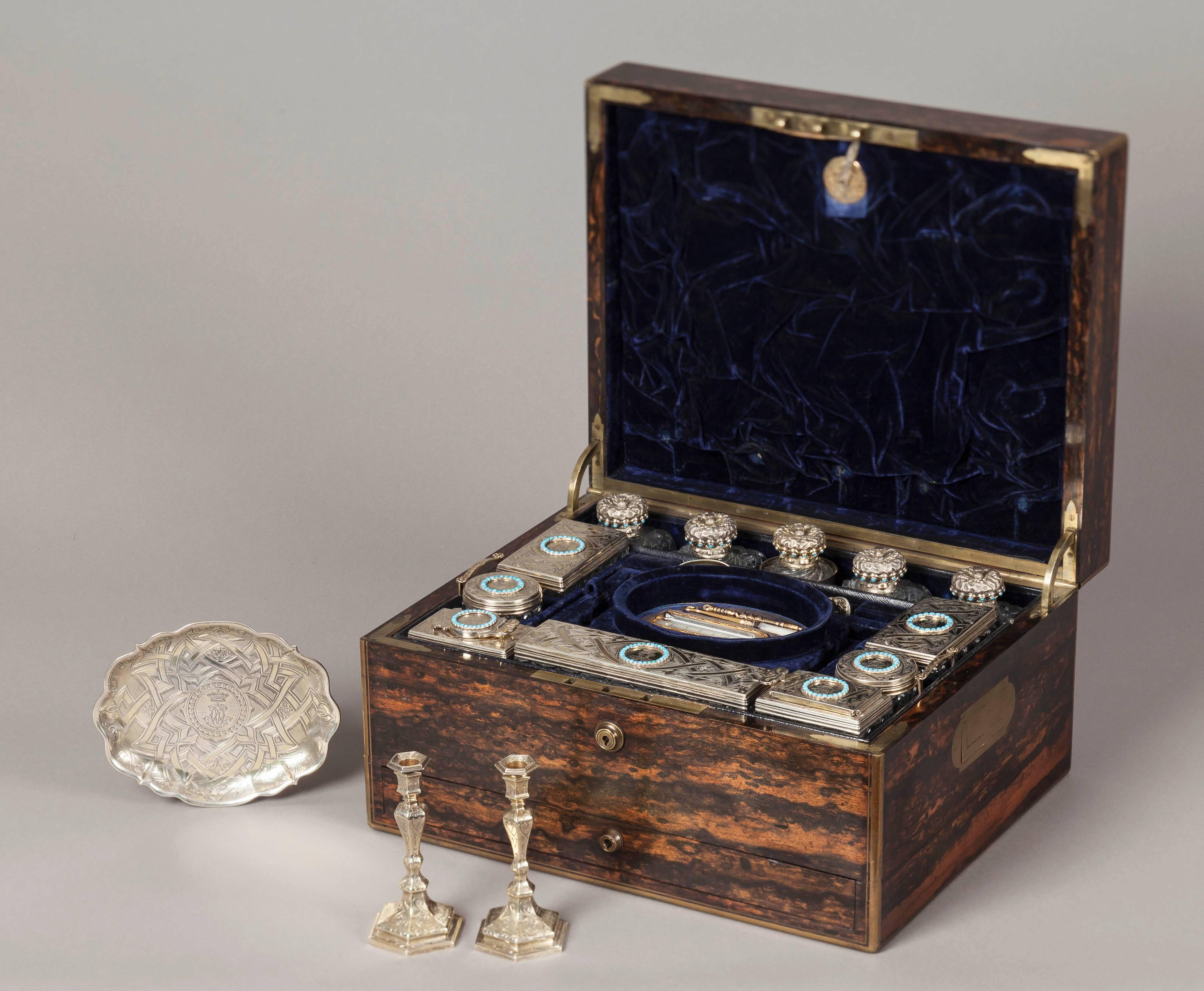 A mid-19th century lady’s travelling dressing case.

The case is constructed in a finely marked coromandel, with inset brass handles and brass guard bands to the angles. The hinged lid rises to reveal in the upper section, a drop down document