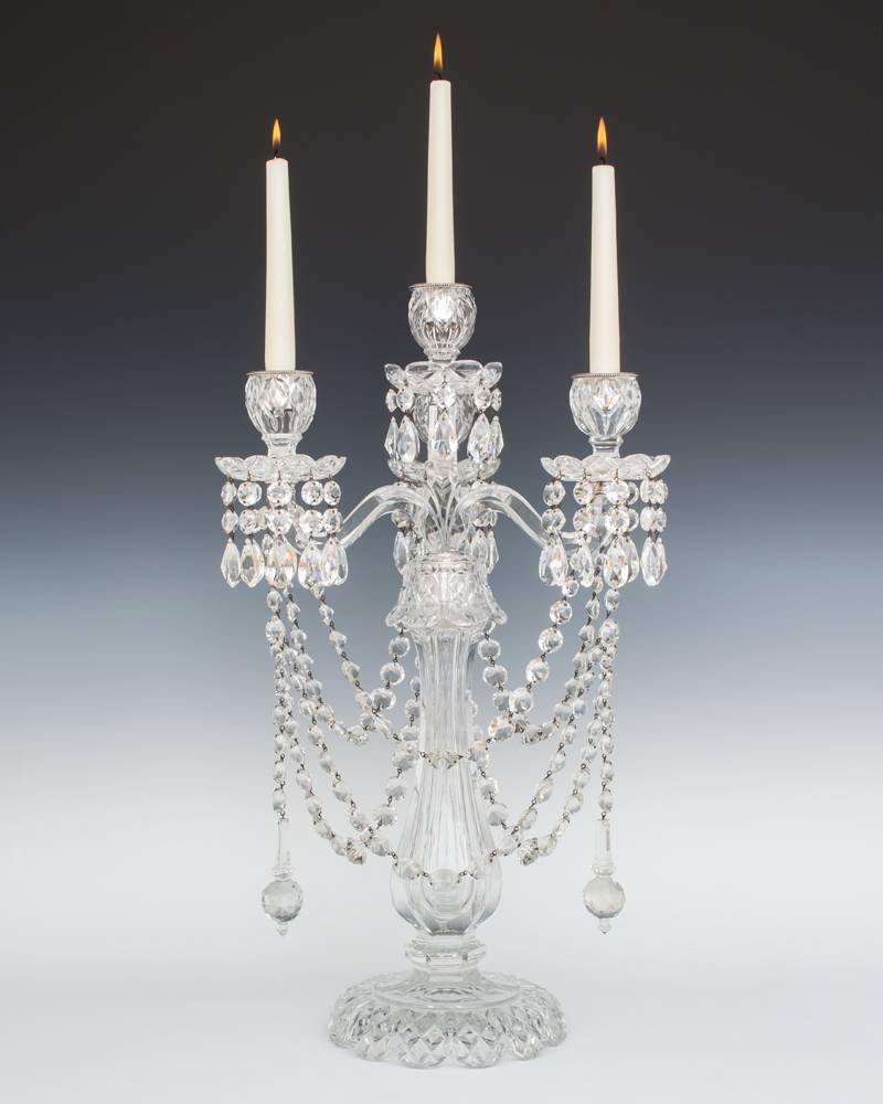 A superb quality pair of crystal candelabra attributed to F & C Osler.

The diamond cut base with fluted column this surmounted by an unusual one piece four branch candle arm this supporting drop hung drip pans and candle nozzles the outer three