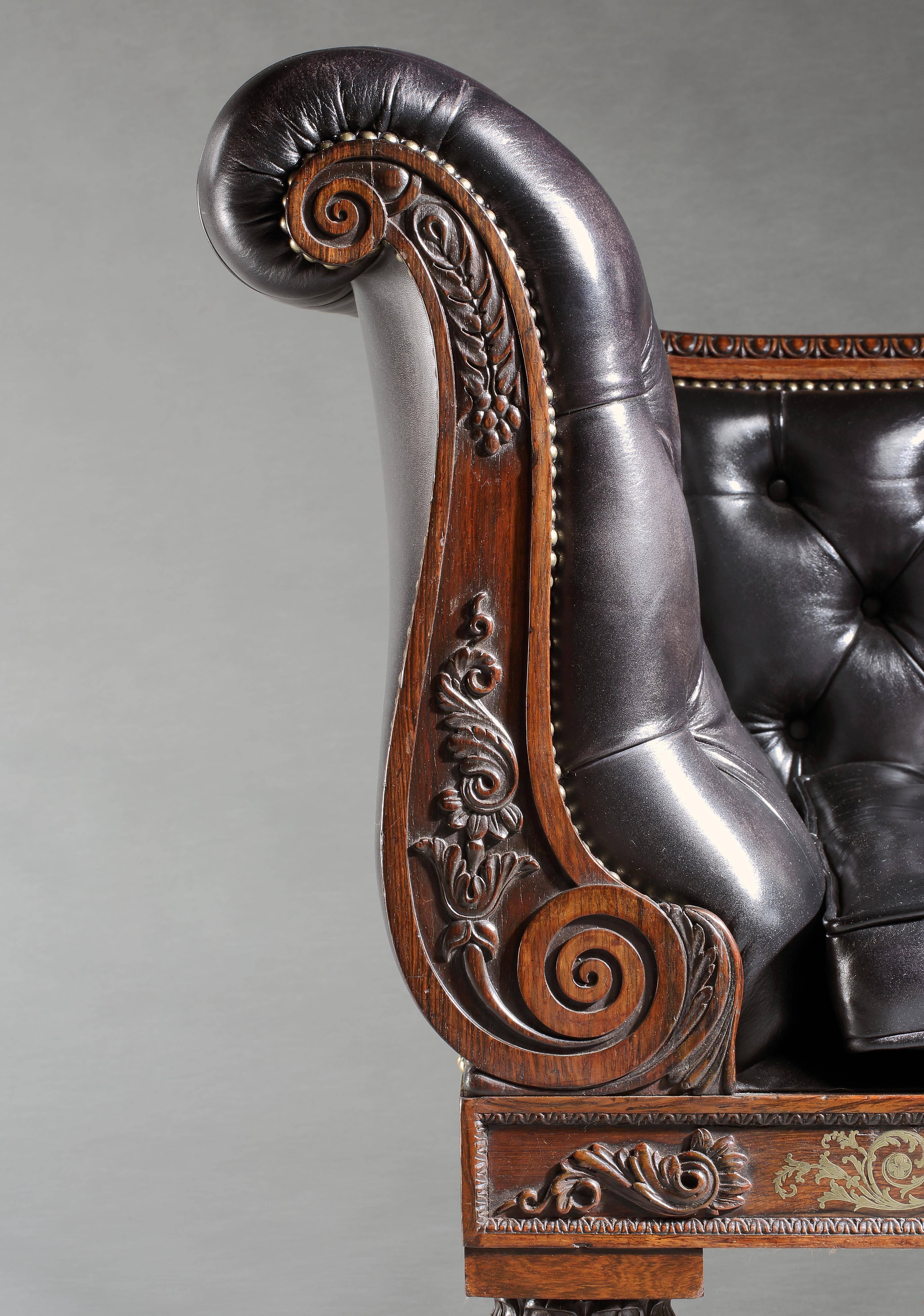 Constructed in Goncalo alves, rising from castor shod tapering lobed legs, the long front rail intricately decorated with cut brass inlaid arabesques, the swept and foliate carved ends of differing heights, conjoined by a running ovolo carved