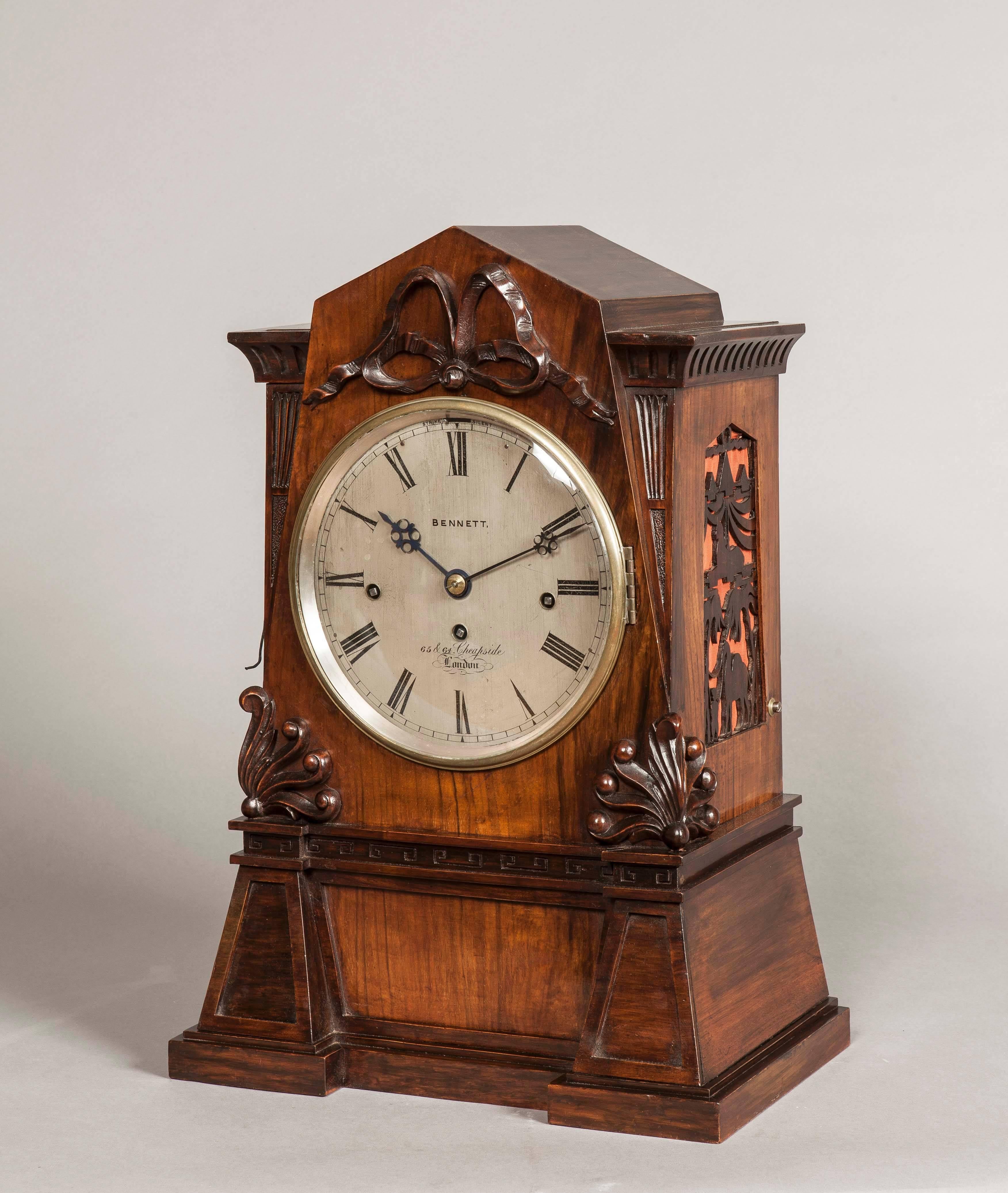 A quarter chiming bracket clock.

The walnut case, of architectural form, is supported on the original bracket, being carved with ribbands, anthemions and pylons in the Egyptian manner, surmounted by a triangulated pediment; the sides have the