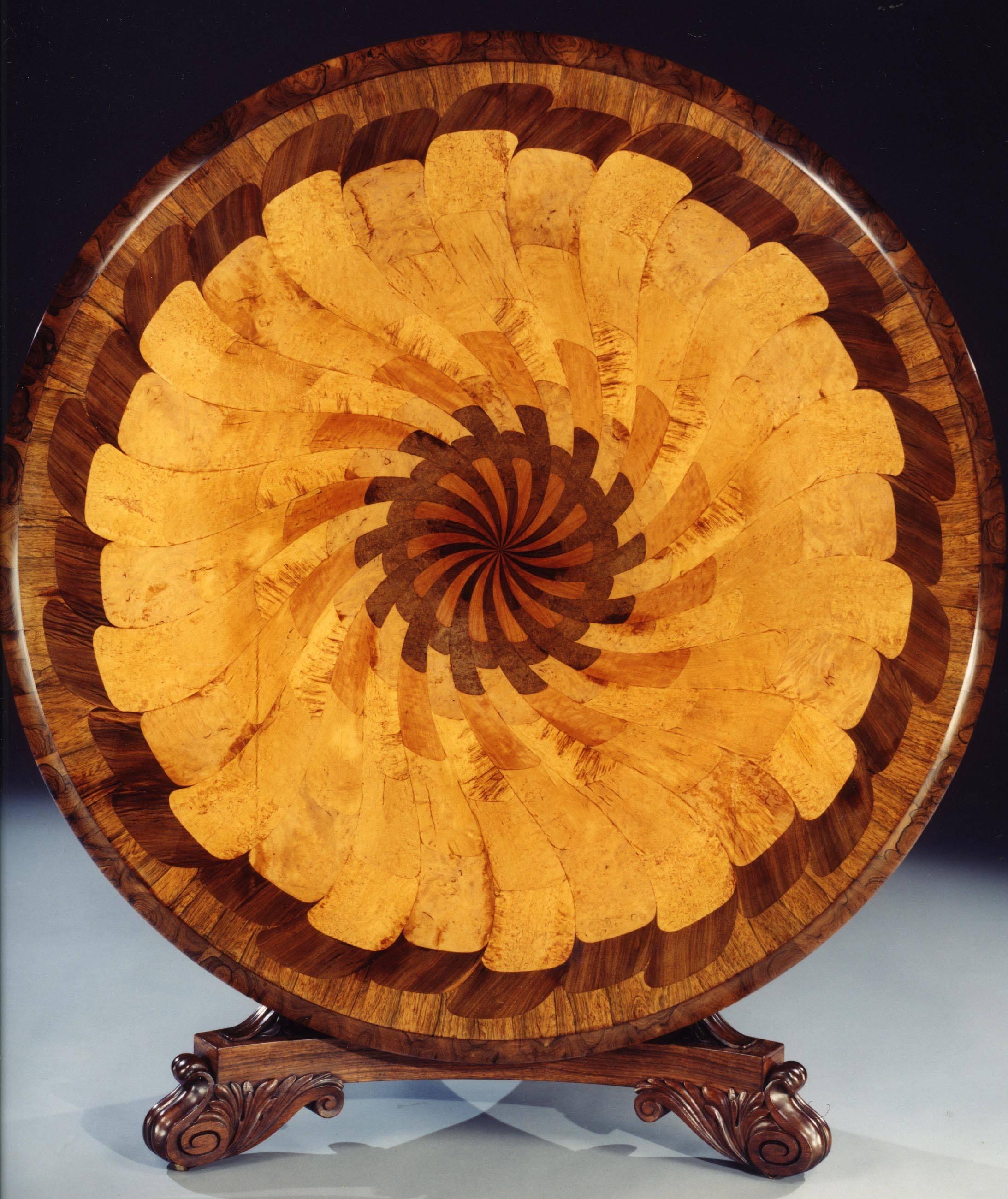 A Remarkable Late Georgian Circular Table

Of a size most unusual in circular tables, constructed in various specimen woods on a San Domingo mahogany ground. The trefoil form platform base, supports a column of truncated incurved pyramidical shape