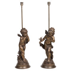 Une paire de lampes de table figuratives en bronze patiné représentant des chérubins